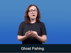 Woman in black T shirt, using hands to create sign language for