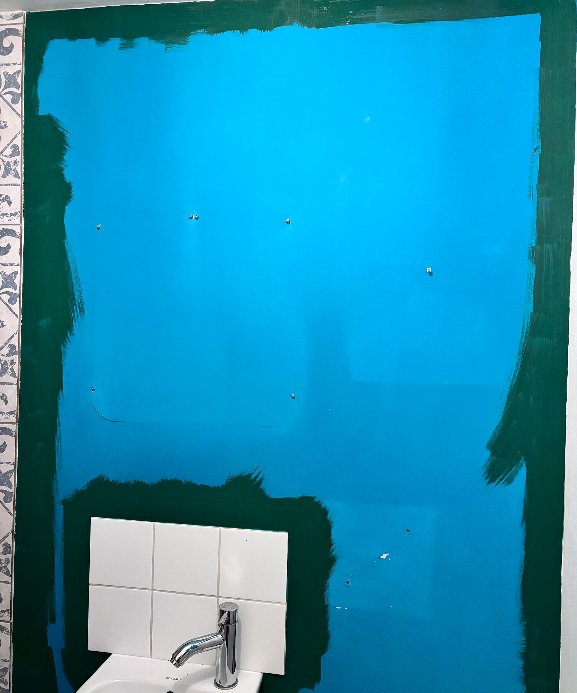 Einschneiden mit dunkelgrüner Farbe auf leuchtend blauer Wand