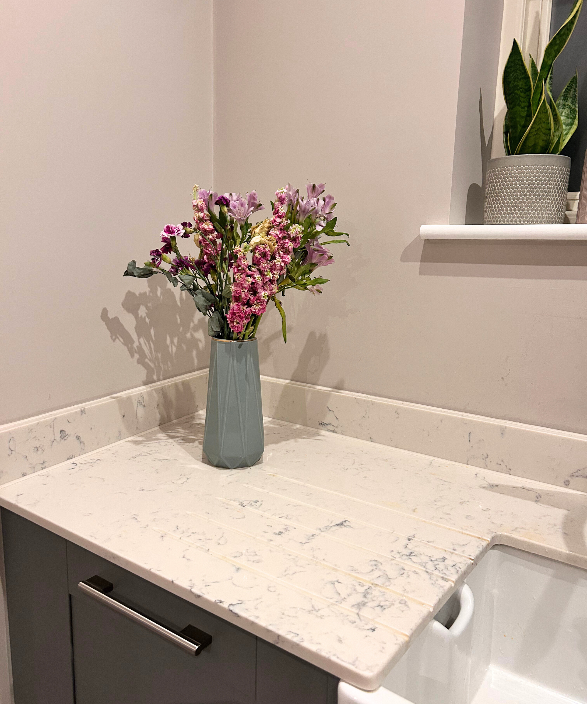 Danach – eine Küchenarbeitsplatte mit Blumen in einer grünen Vase darauf