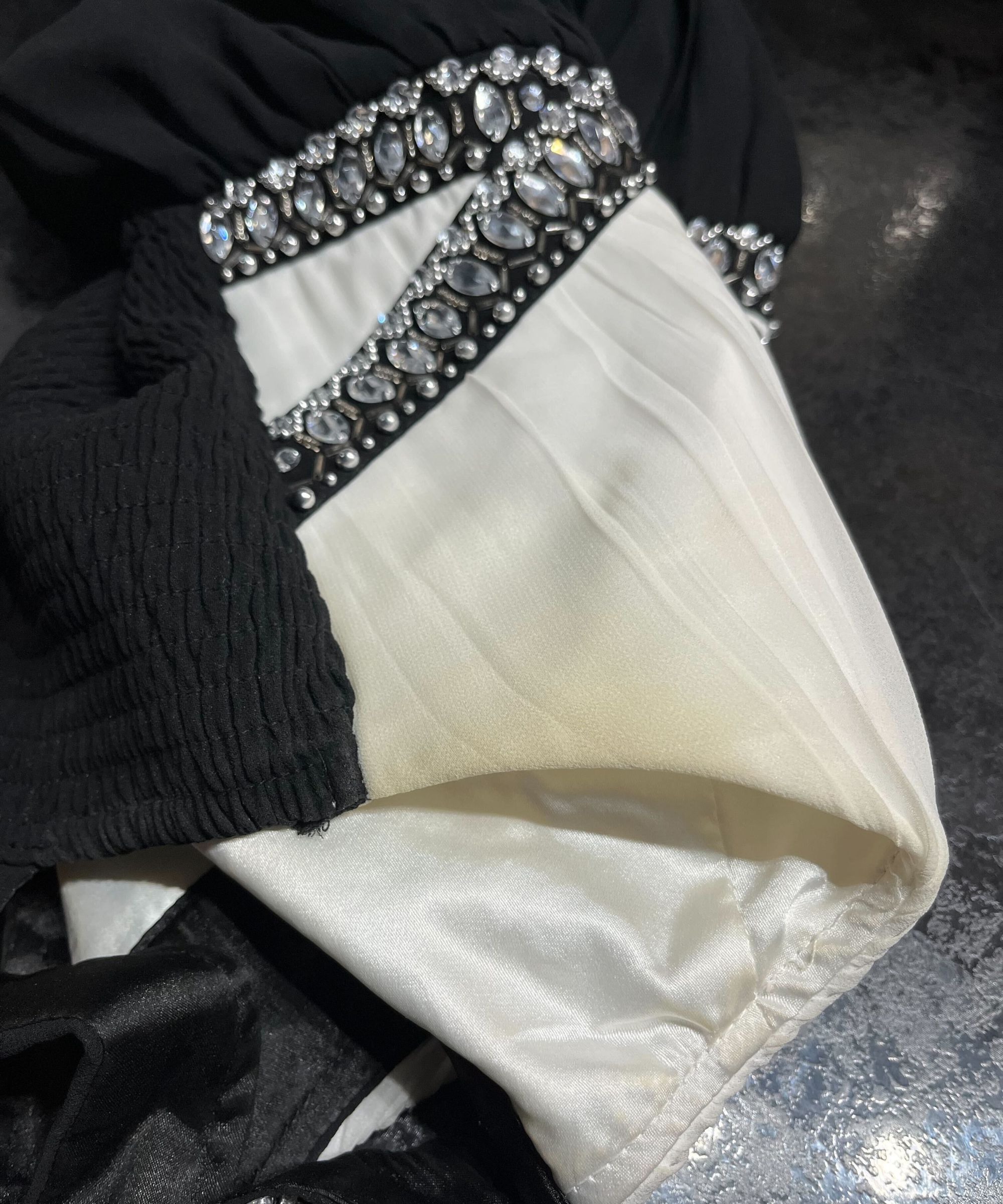 Eine Creme und ein schwarzes Kleid mit einem vergilbenden Fleck in der Achselhöhle