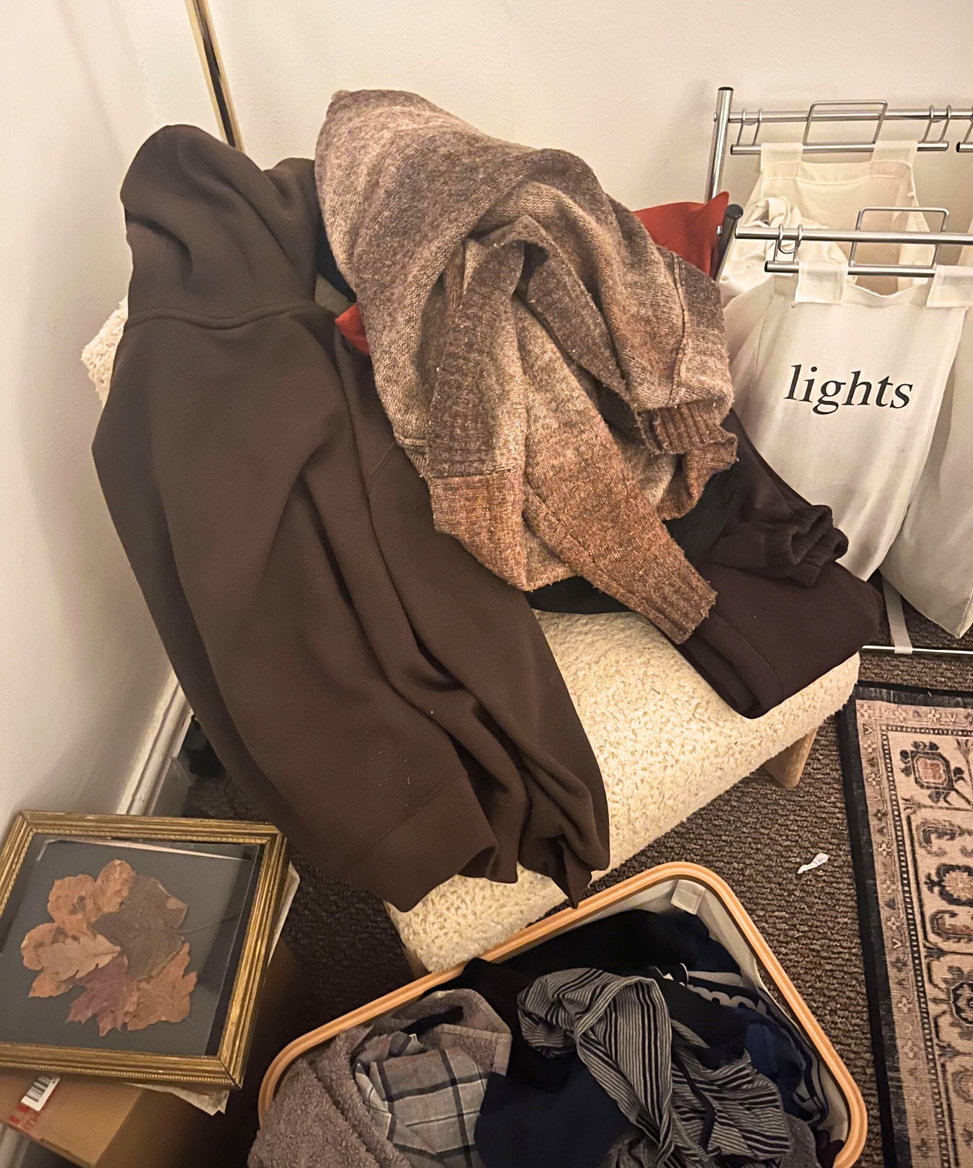 Ein unordentlicher Haufen Kleidung auf einem Stuhl in der Ecke eines Raumes