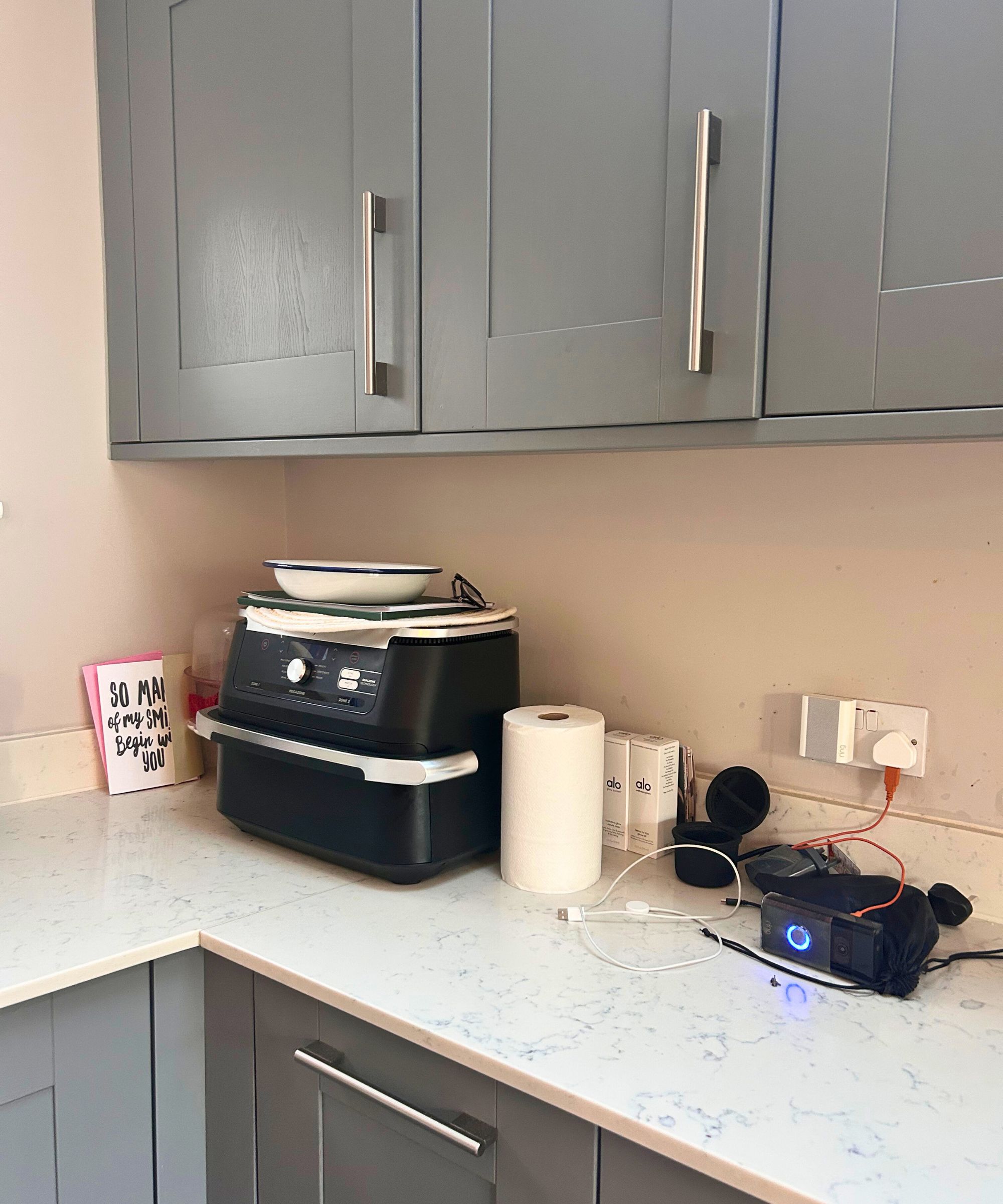 Unordentliche Küchenarbeitsplatte mit einer Ninja Air Fryer, Karten und Küchenrolle 
