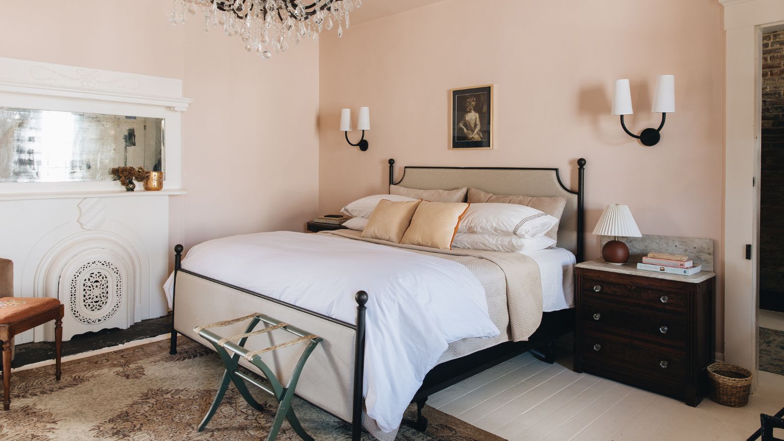 calming bedroom with pale pink walls, dark wooden furniture and white bedding
