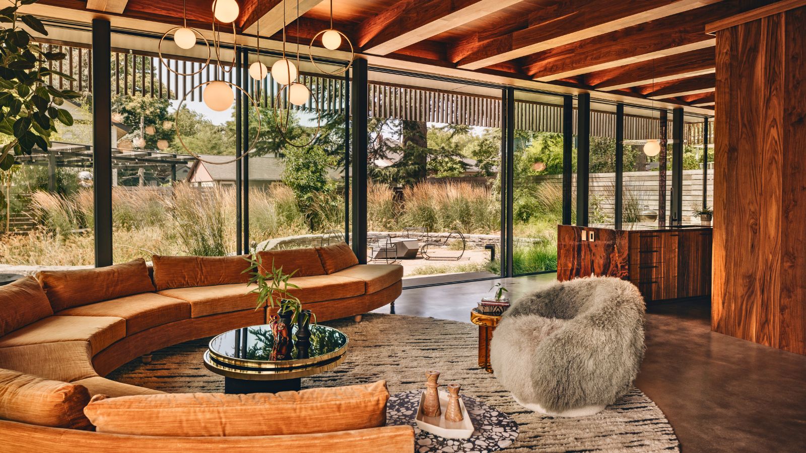 glass walled living room with curved sofa