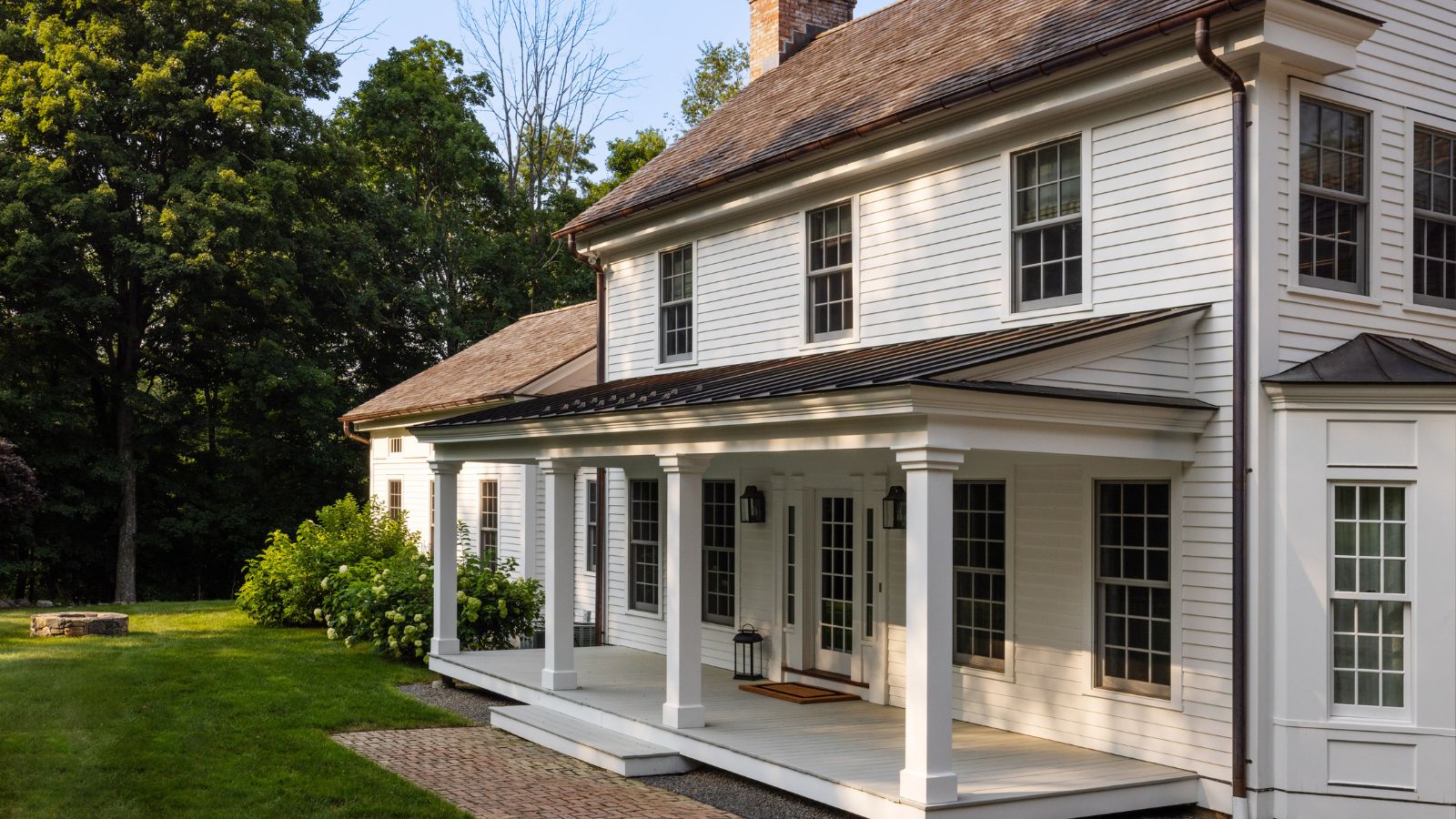 White traditional timber clad home with porch