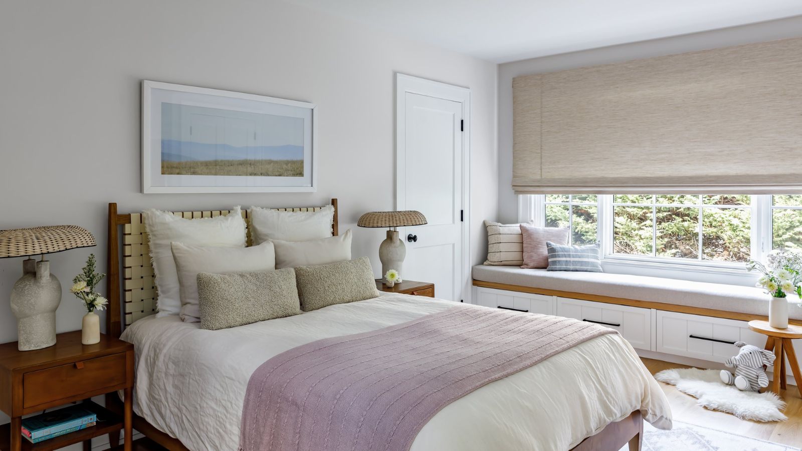 Kleines Schlafzimmer mit hellem Fenster und natürlichen Akzenten. Es gibt ein Holzbett und einen Nachttisch mit einem Banksitz unter dem Fenster