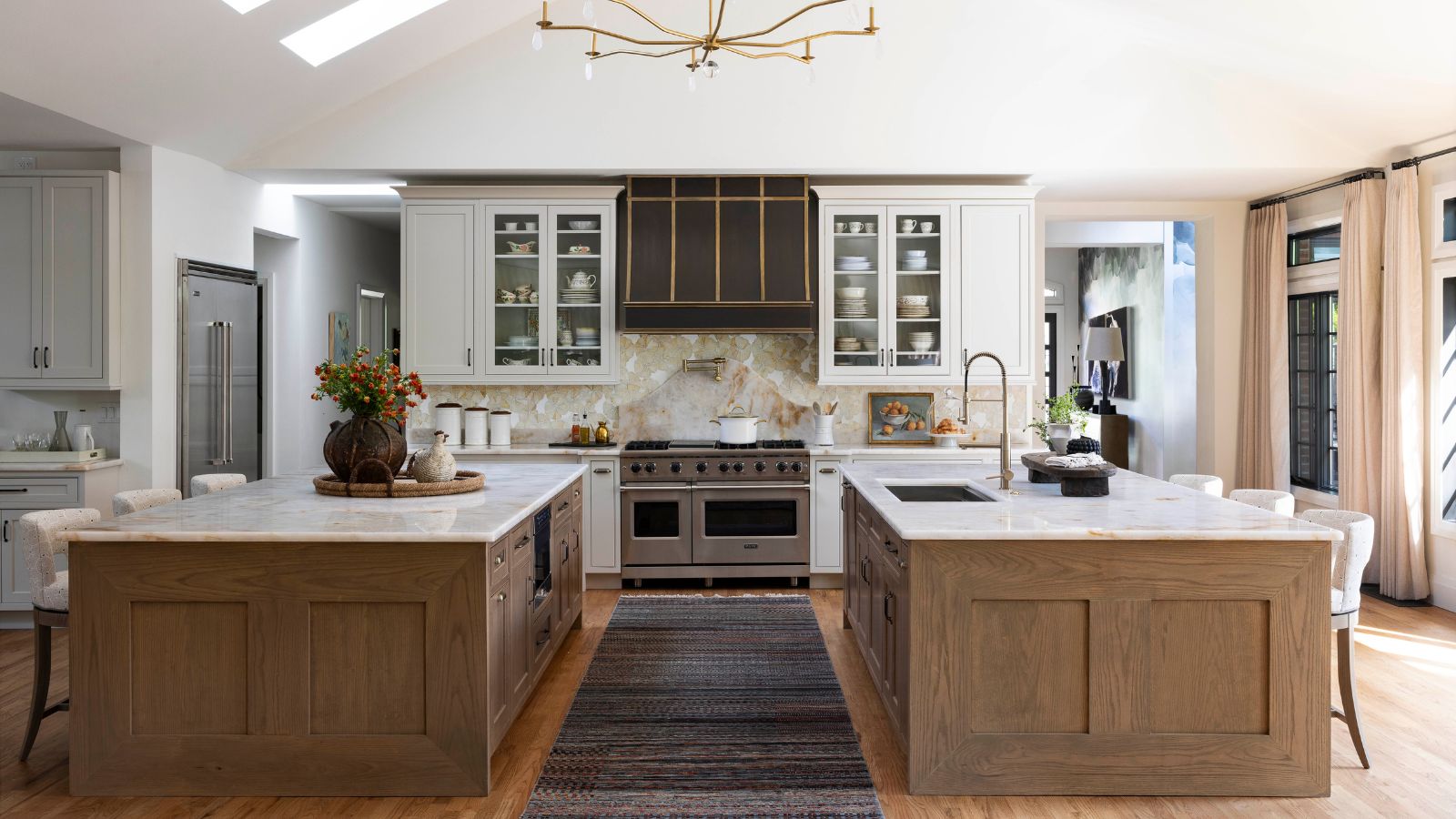 White kitchen with two wooden islands and a gray runner in between