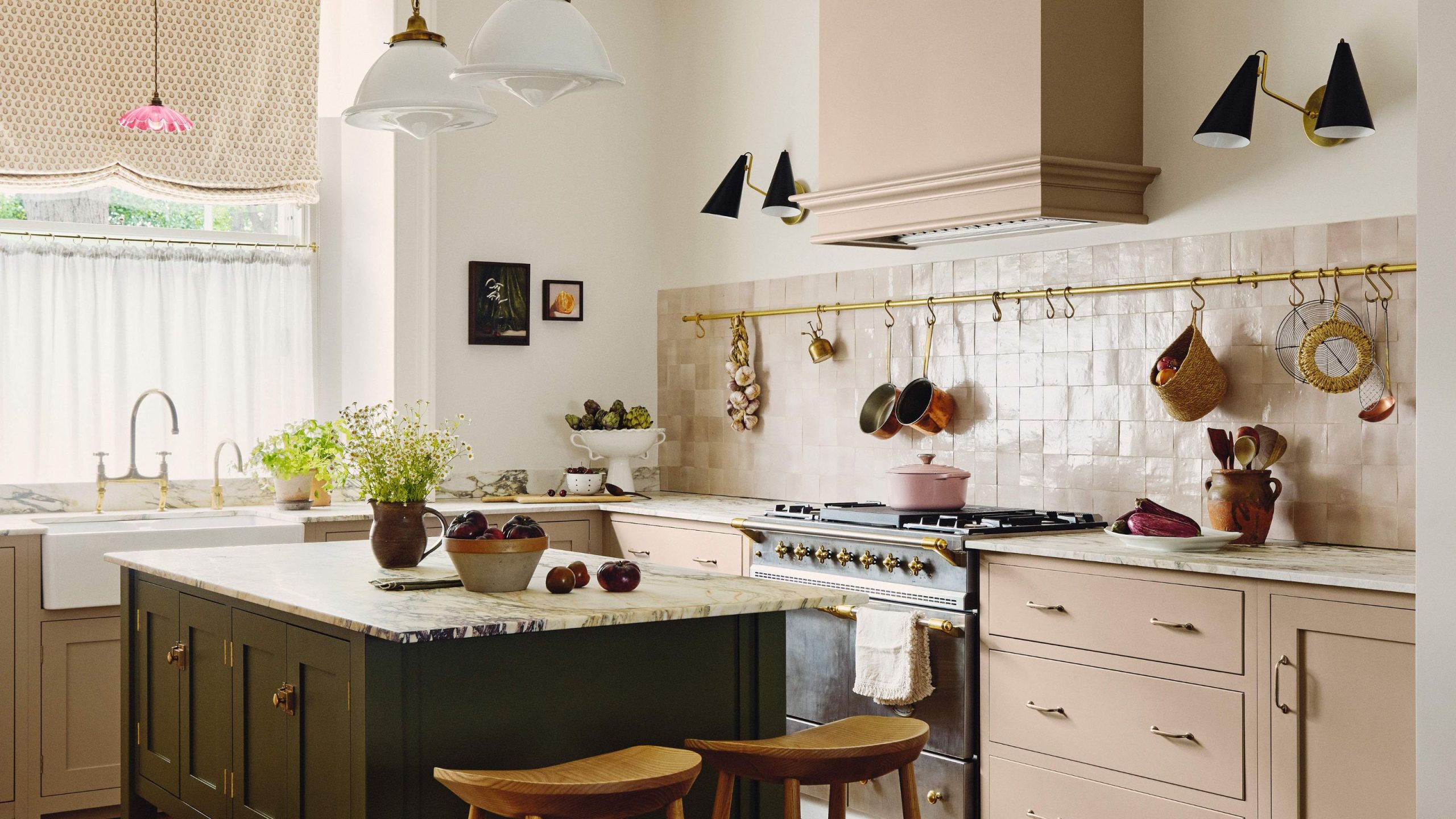 Pale pink kitchen with dark green island and pink textured tile splashback