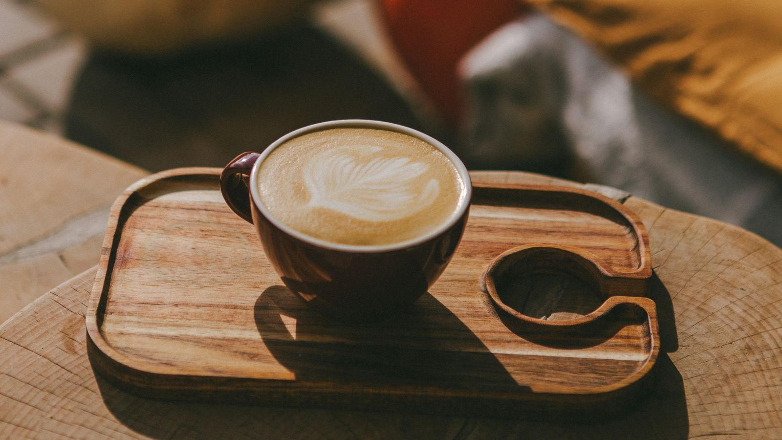 Pumpkin spice latte on a wooden board in the sunshine