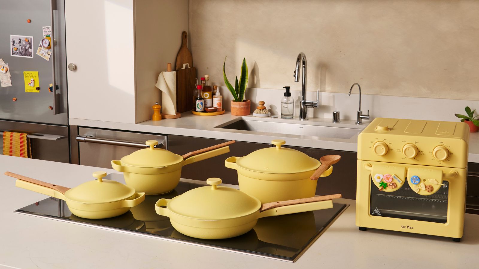 Butter yellow Our Place cookware on induction hob with yellow Wonder Oven beside