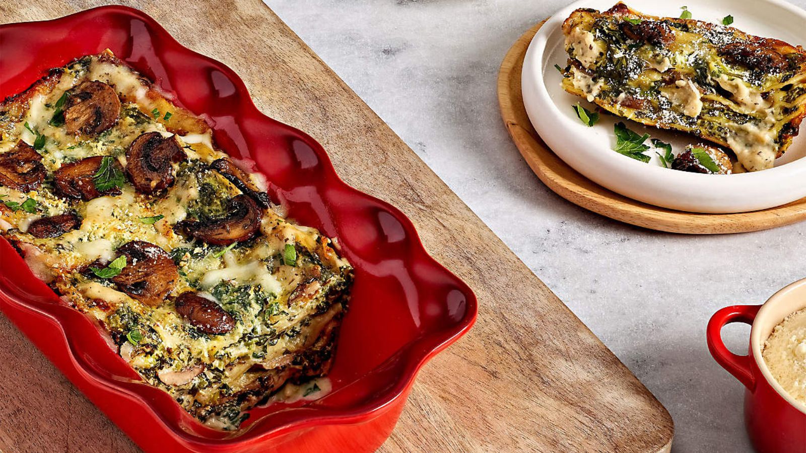 Red fluted Le Creuset loaf pan next to red mug