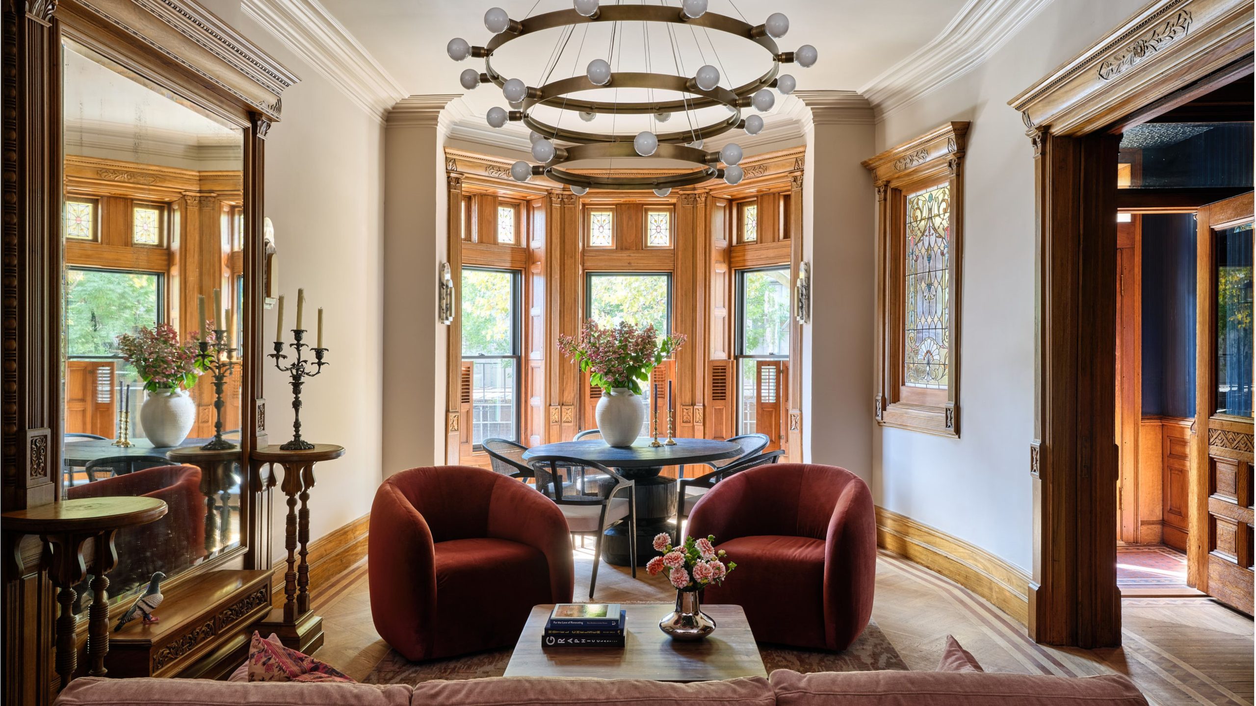 Historic tudor-style living room with original moulding, wood-framed window nook, and modern interior accents