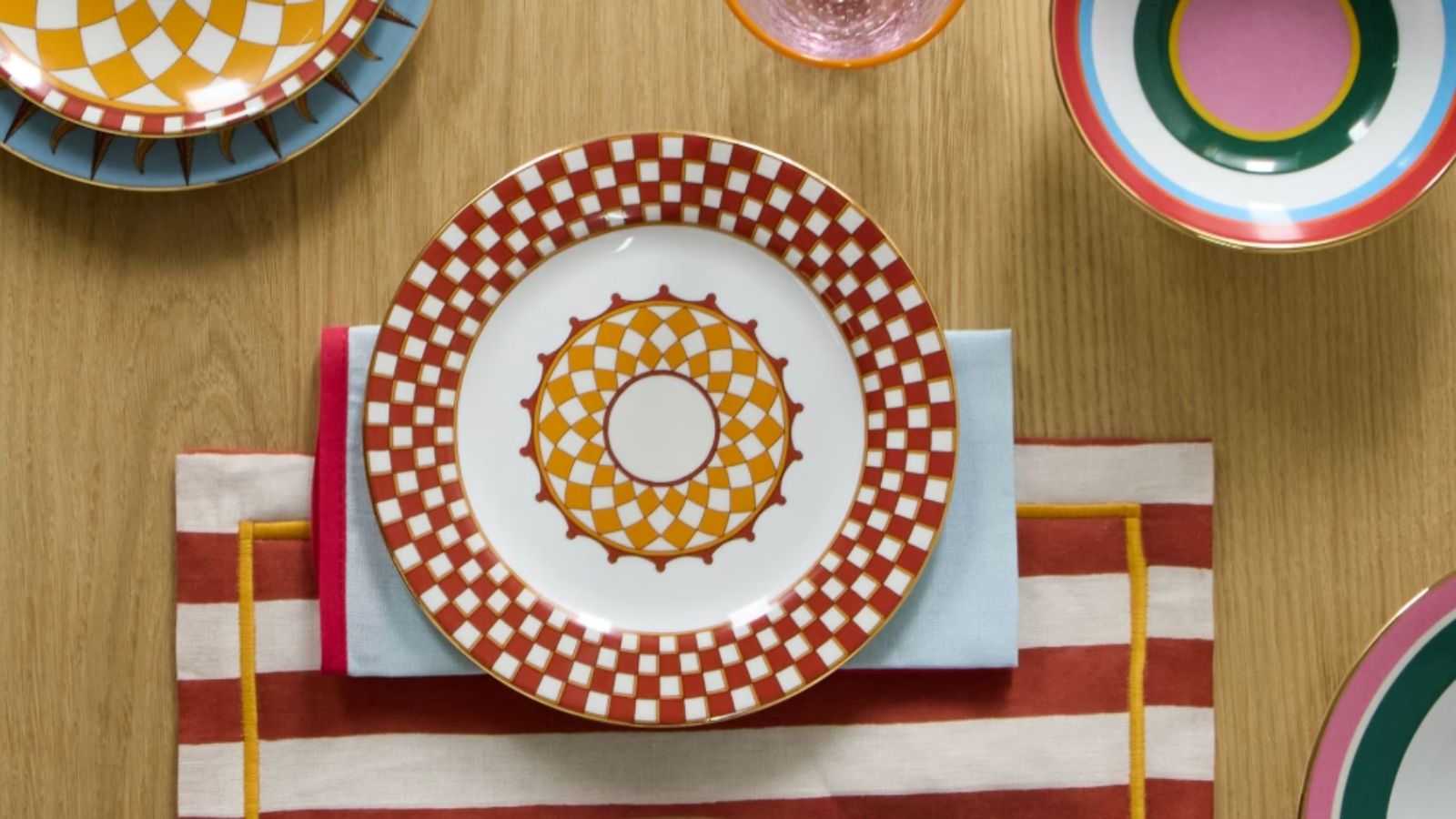 Colorful tableware in geometric prints and striped fabric placemats