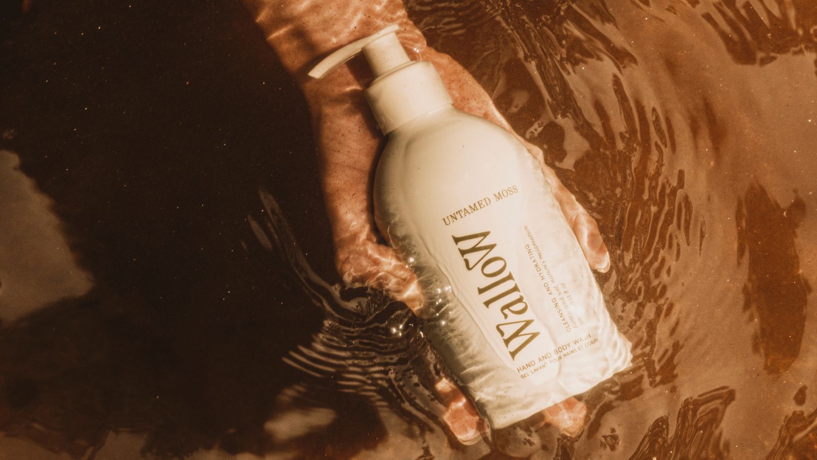 White bottle of body wash in rock stream