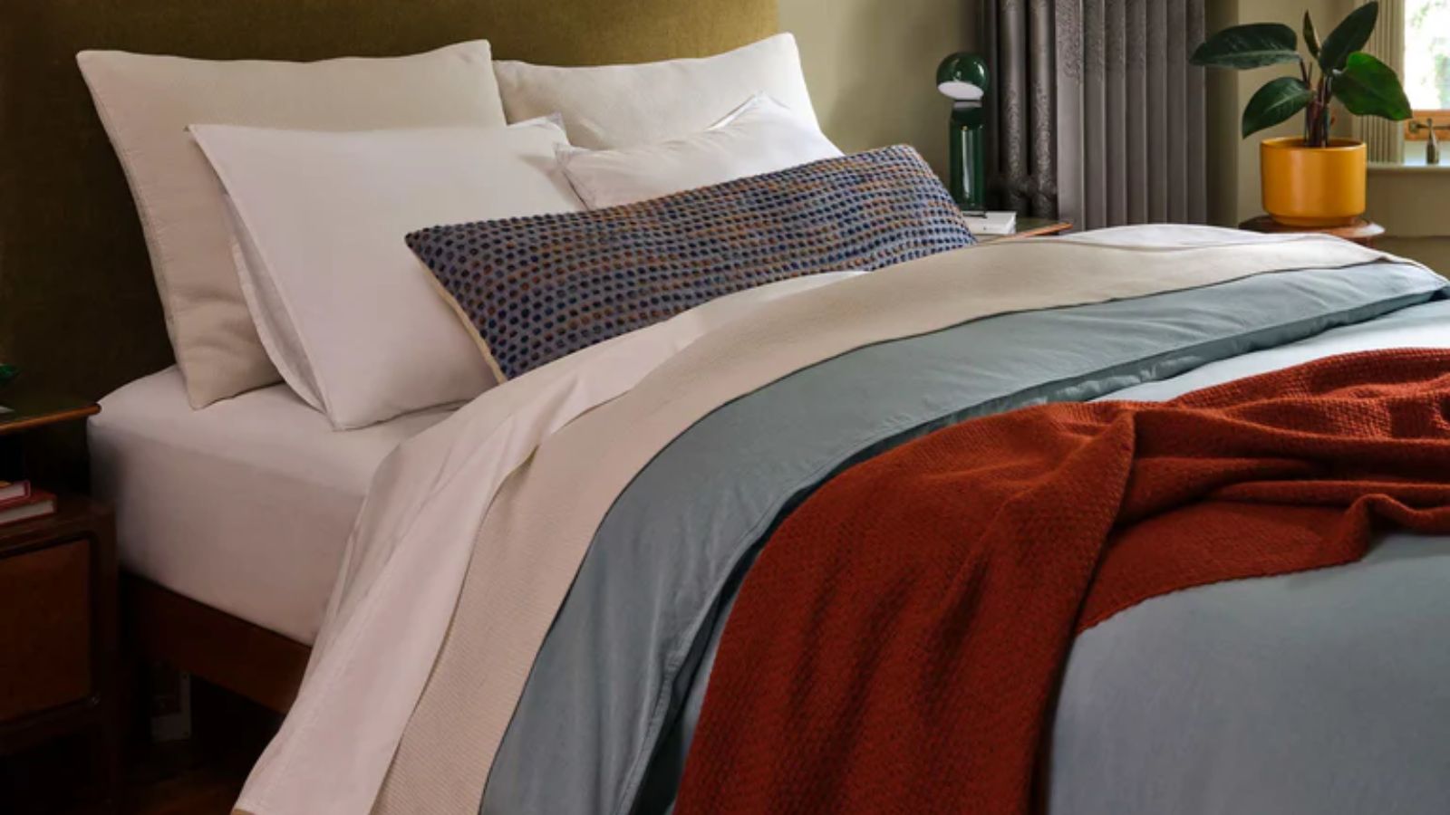 Bed sheets with blue comforter, white pillows and taupe sheet