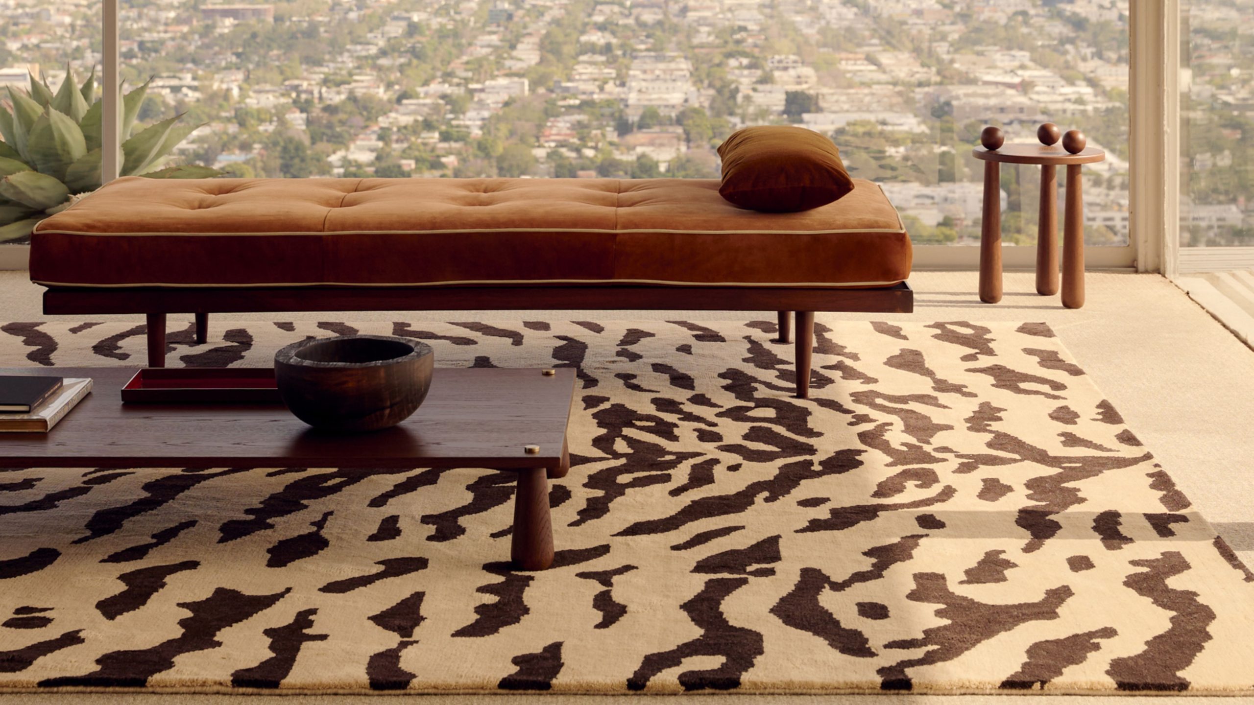 Nordic Knots Tigris rug in brown and beige pictured in an open concept mid-century living room with low slung furniture, including a chaise lounge and coffee table