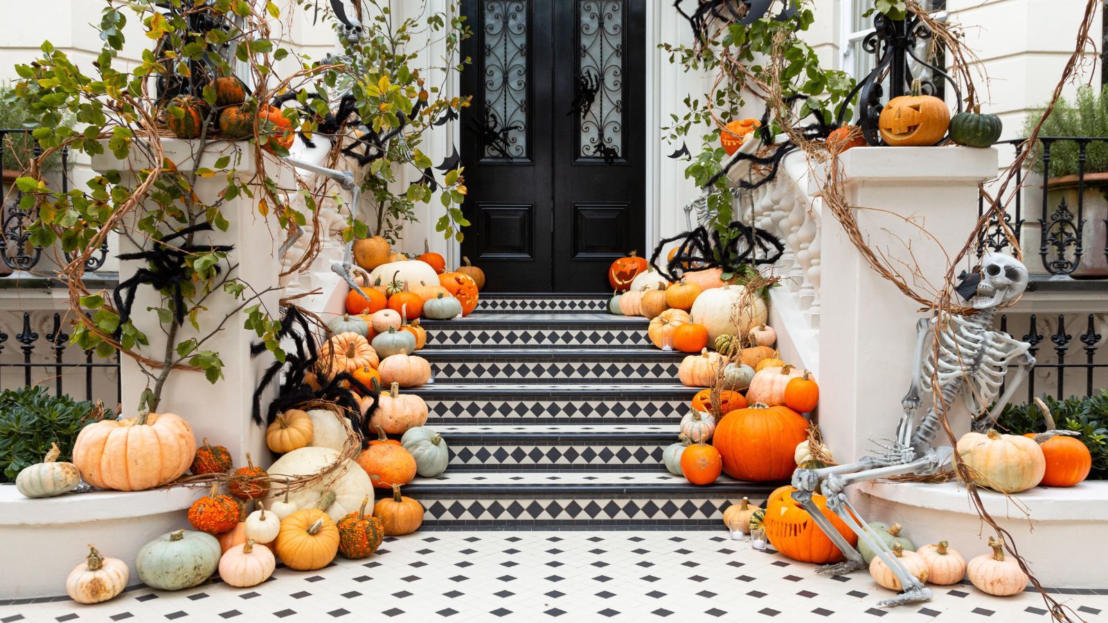 A beautiful arrangement of different types of pumpkin on the front steps of a house at Halloween