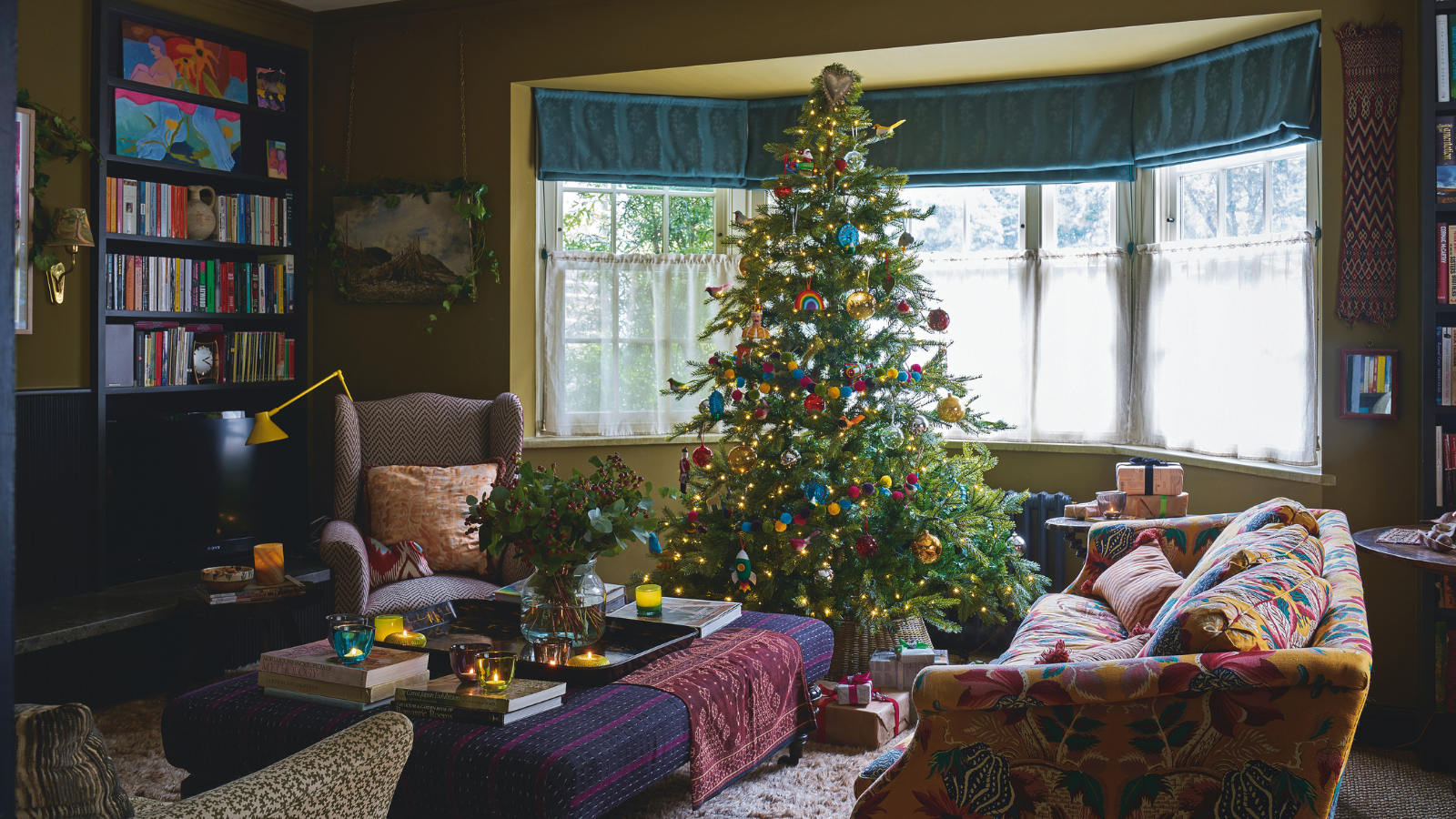 colorful and patterned living room with green walls, a bay window and a Christmas tree