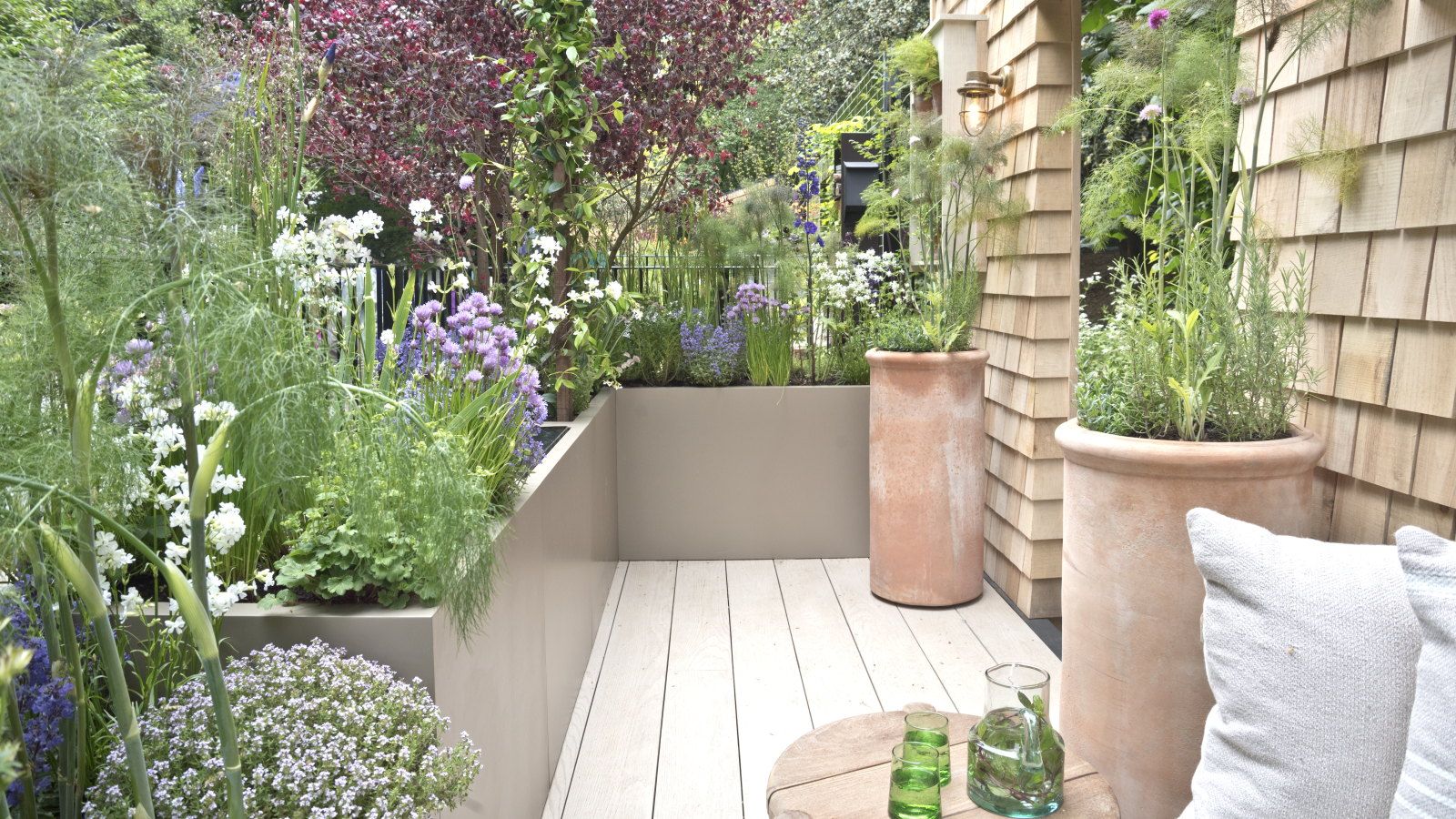 A balcony garden with plants growing in terracotta pots and raised planters at the Chelsea Flower Show