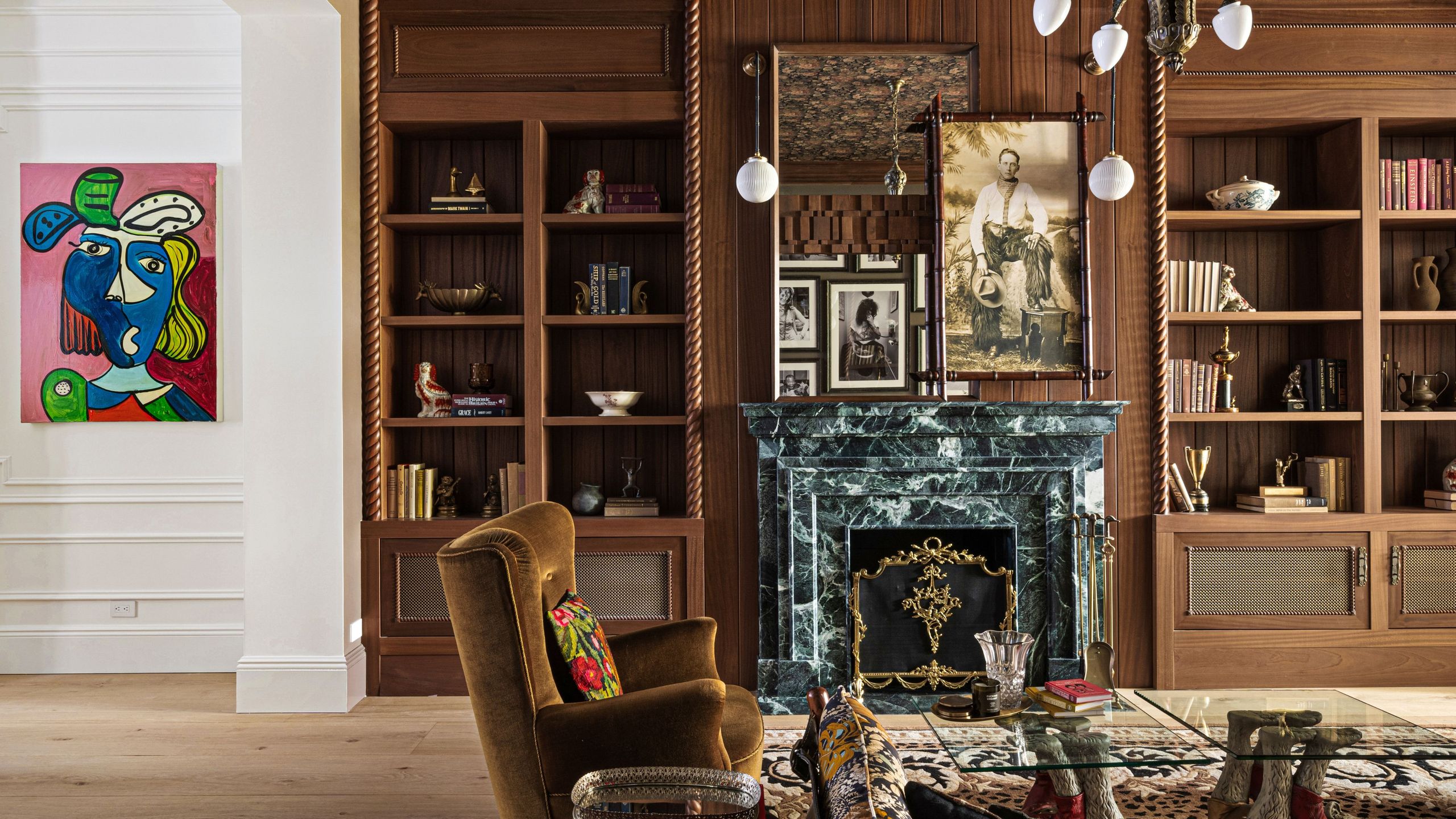 NYC parlor room featuring warm woods, a green marble fireplace, and contemporary artwork