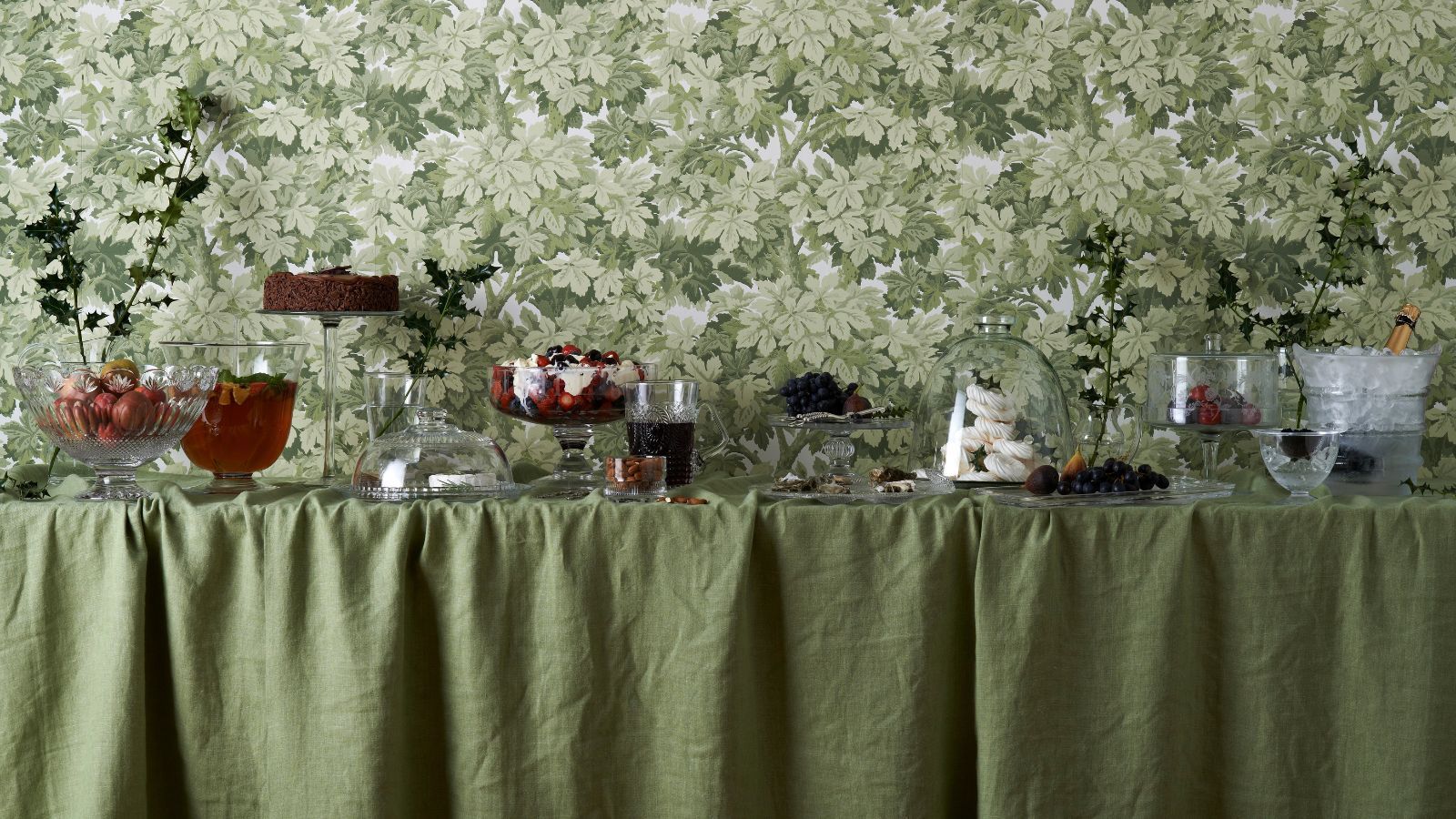 Sage green Christmas buffet table with green floral wallpaper behind