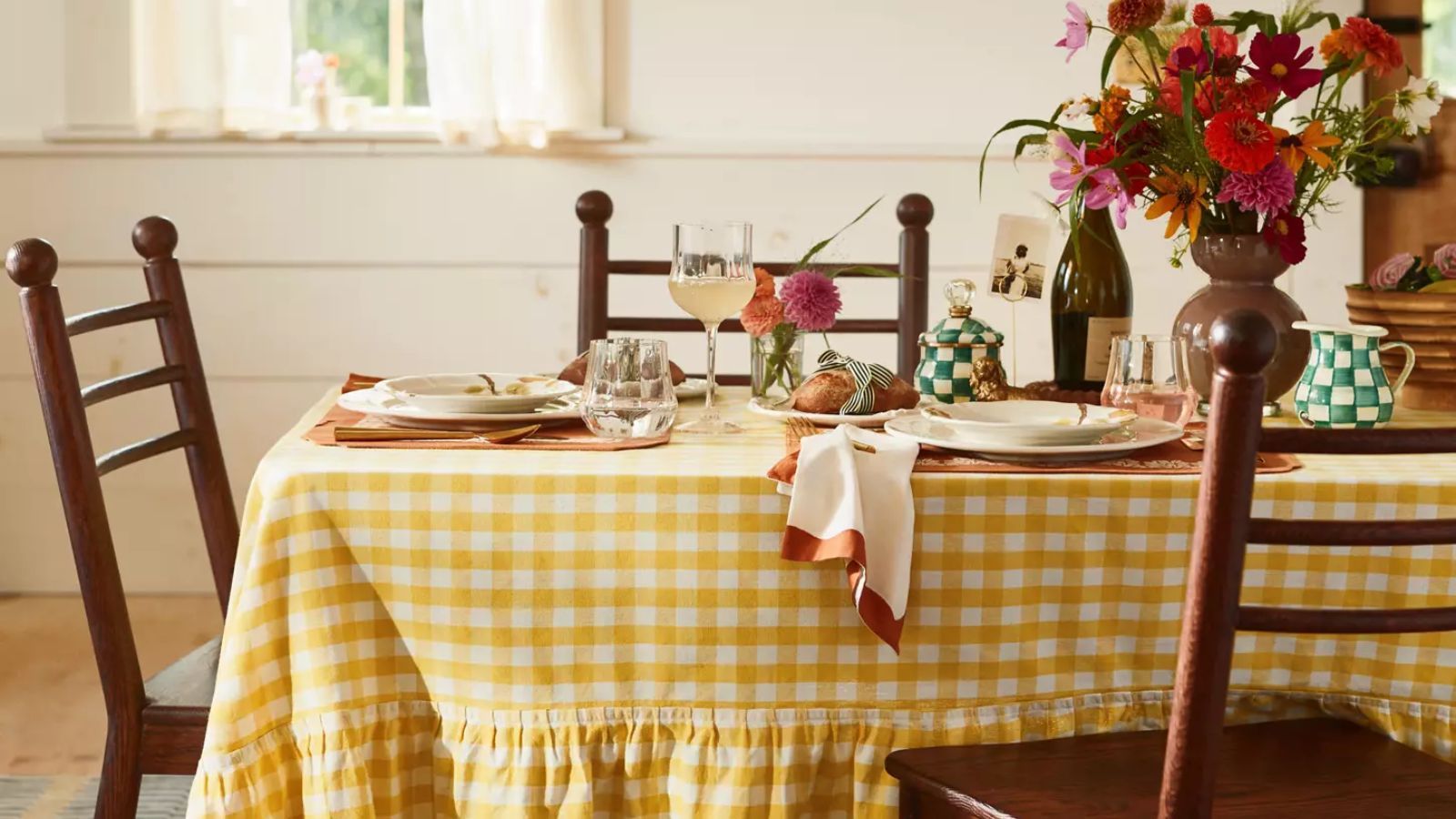 Table with yellow gingham tablecloth and green checkerboard drinkware
