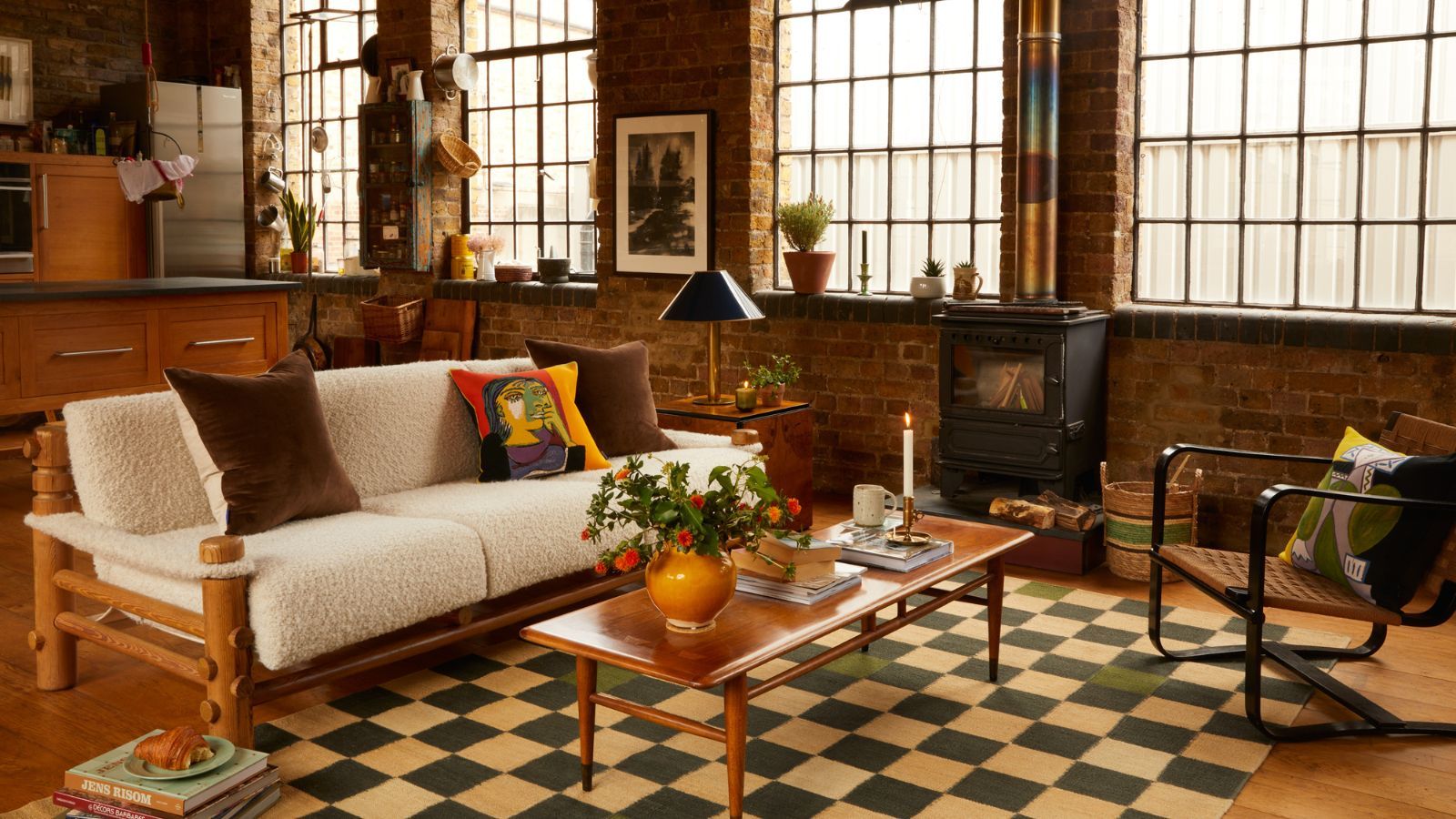 An open plan living room with a checkerboard rug and a sofa with curved details