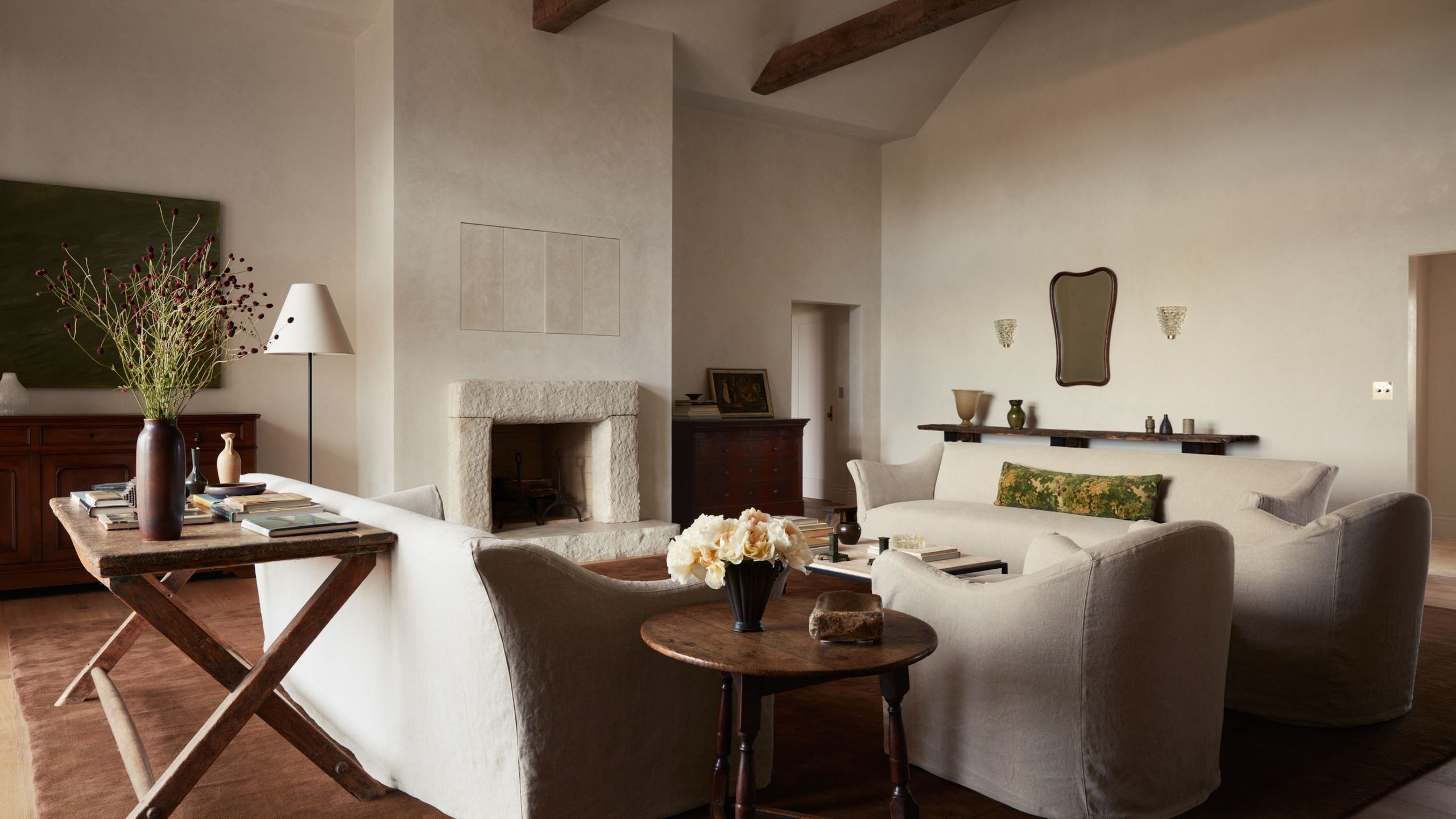 neutral living room with off-white sofas around a stone fireplace