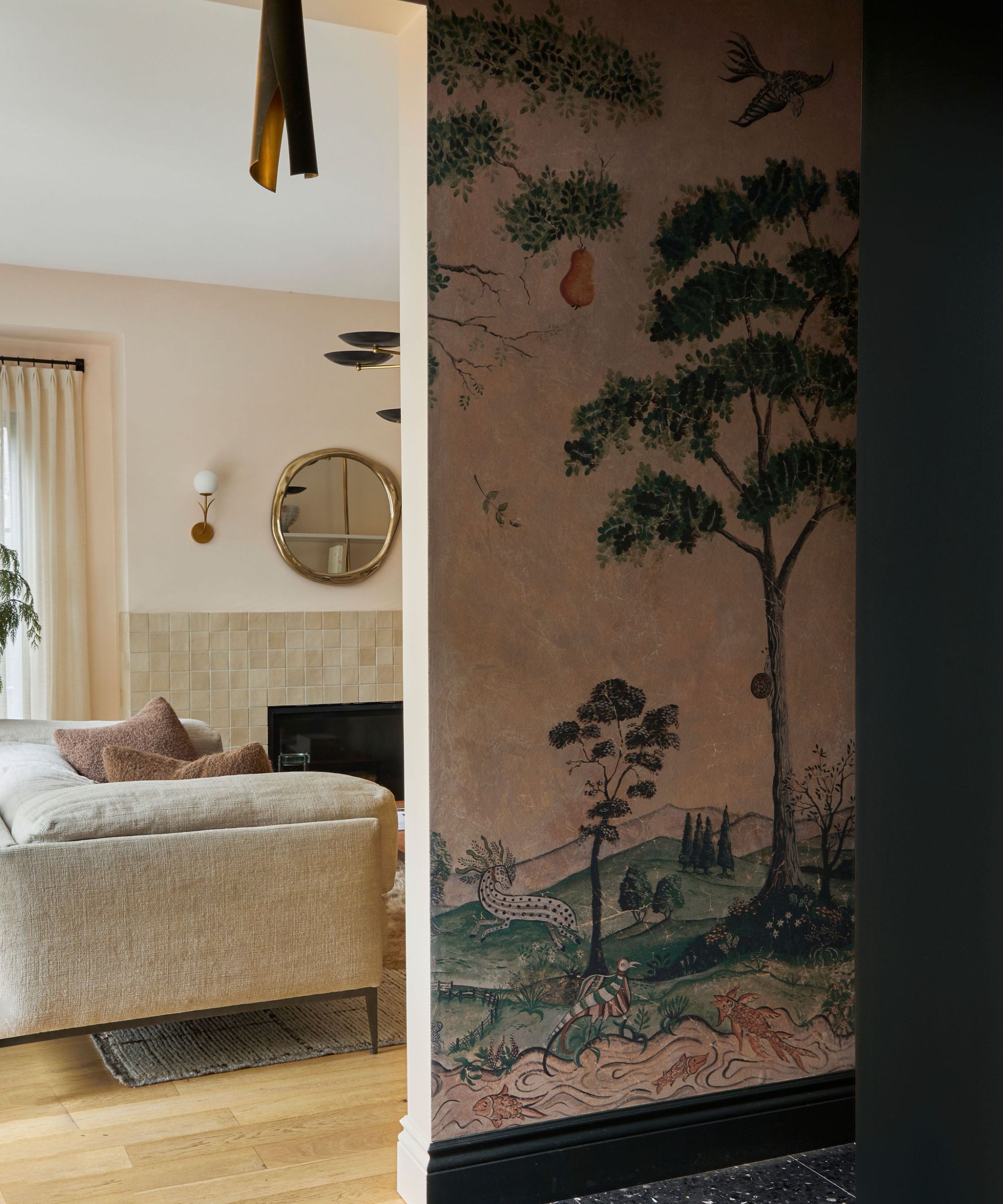 Ein neutrales Wohnzimmer mit großen schwarzen Metallfenstern, die eine Wand einnehmen. Es gibt ein großes beiges Sofa, auf dem ein Hund sitzt, und auf der linken Seite einen Baum. Vorne steht ein großer Couchtisch aus Holz