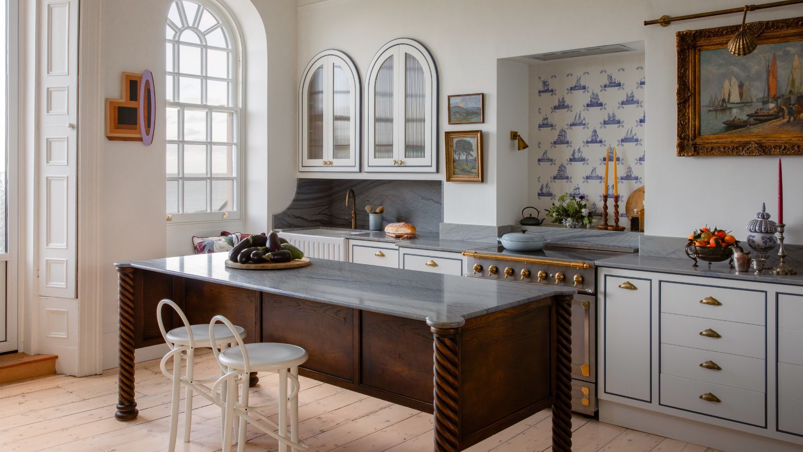 a white traditional kitchen with arched windows and arched cabinetry with a wooden kitchen island