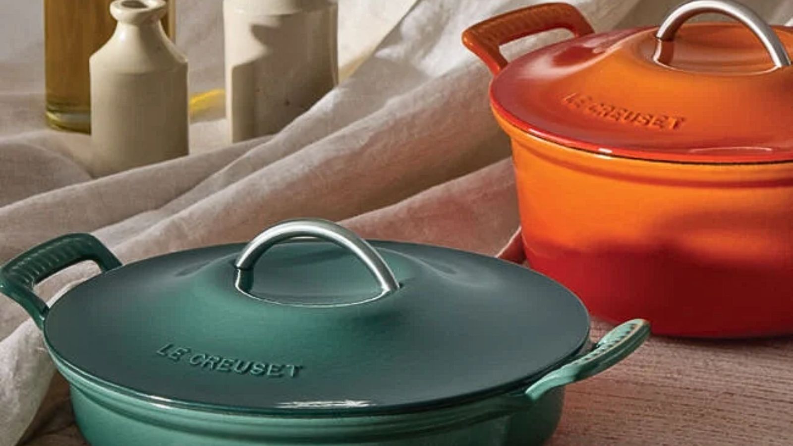 Zwei holländische Öfen von Le Creuset, einer blau und einer orange. 