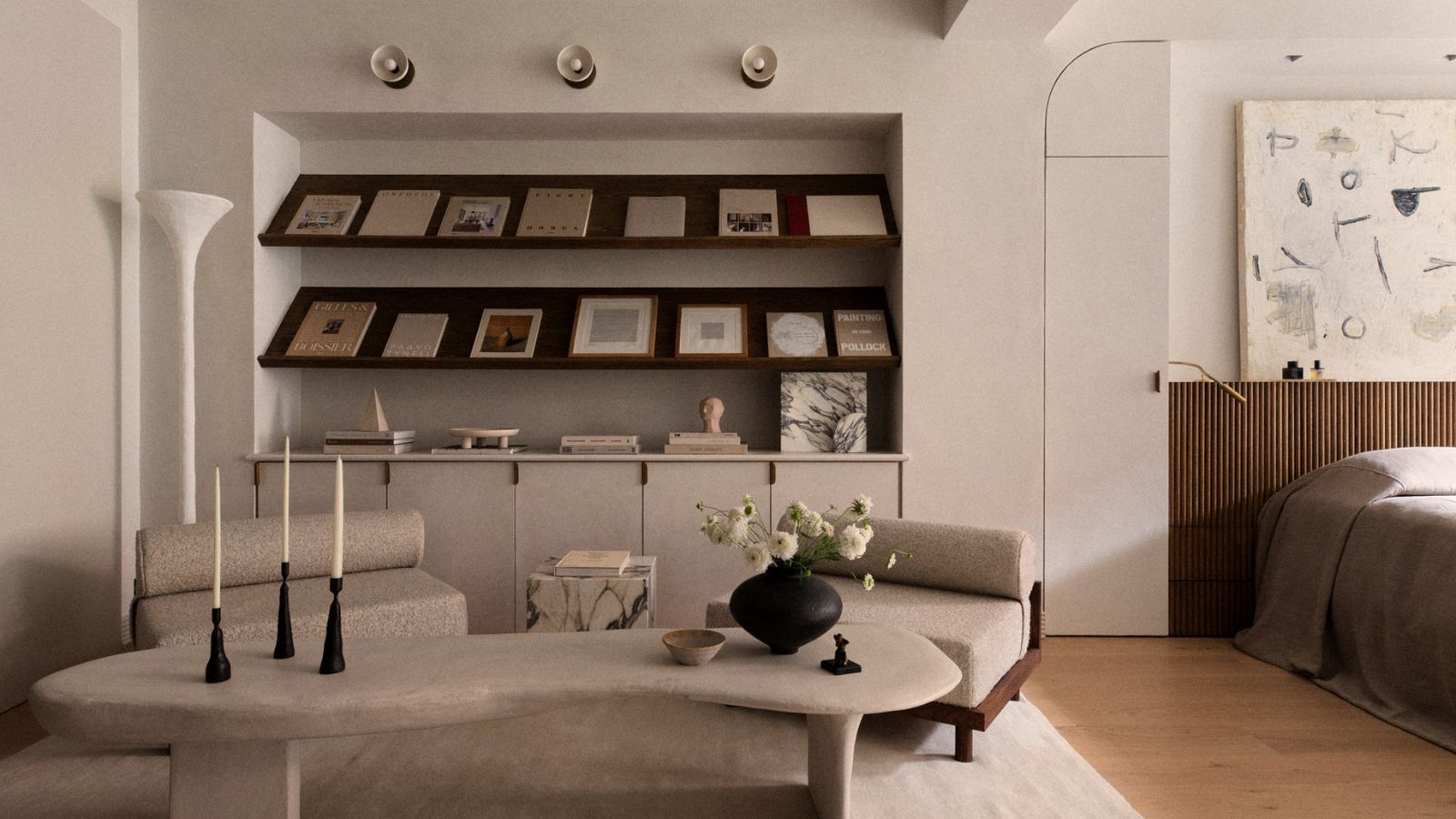 Minimalistisches Wohnzimmer mit Bouclé-Stühlen, Couchtisch aus Stein und Bücherregalen