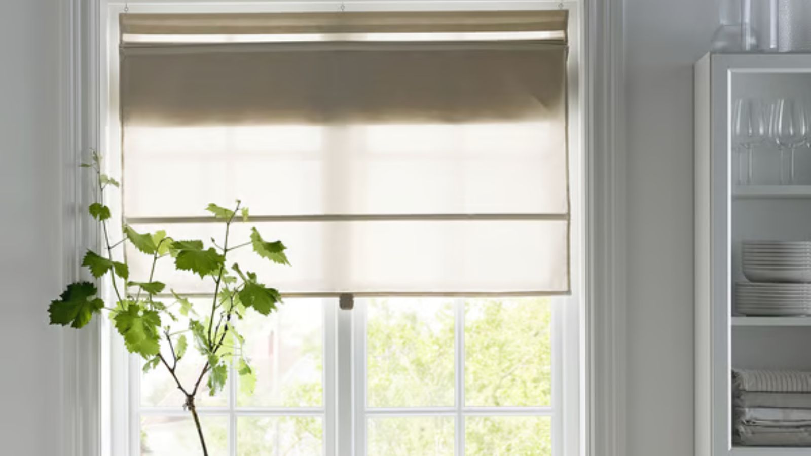 Neutrales Leinenrollo am Küchenfenster, rechts Regale und Geschirr