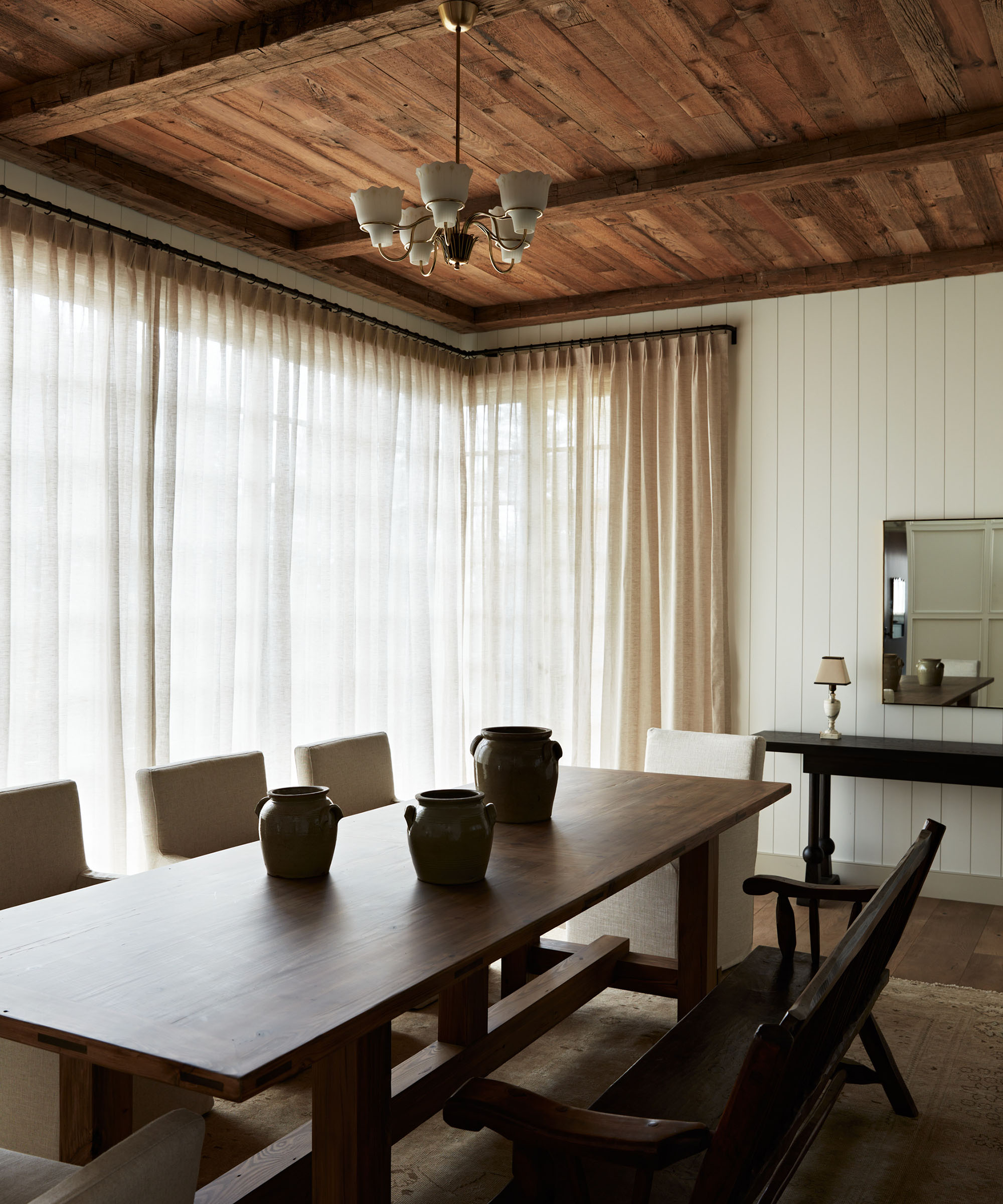 Esstisch neben hellen, transparenten Vorhängen