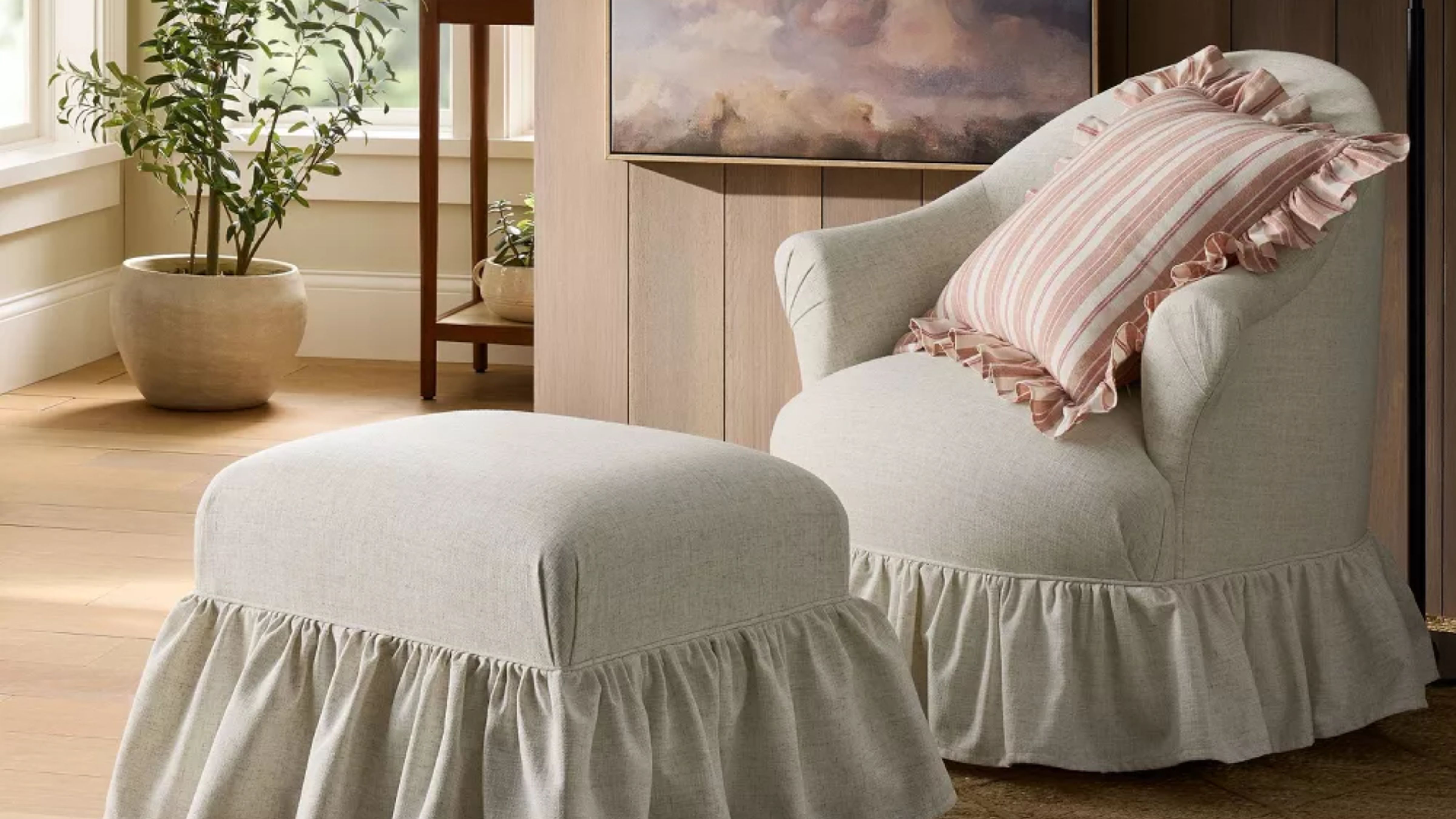 Von Shea McGee entworfener Rüschendrehstuhl und passender Ottomane, abgebildet in einem holzgetäfelten Wohnzimmer