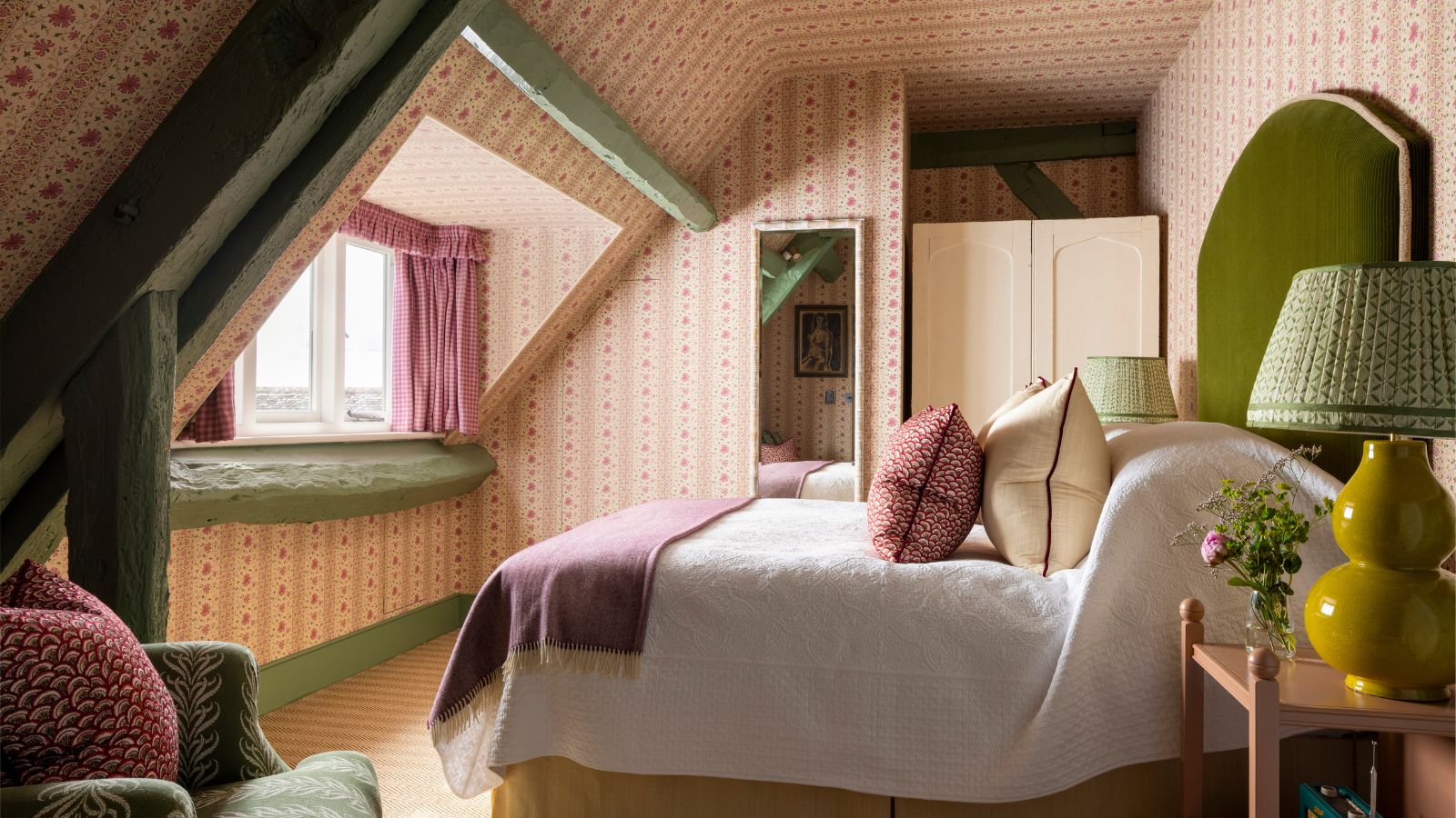 Ein gemütliches, traditionelles Schlafzimmer mit rosa und grünem Dekor. 