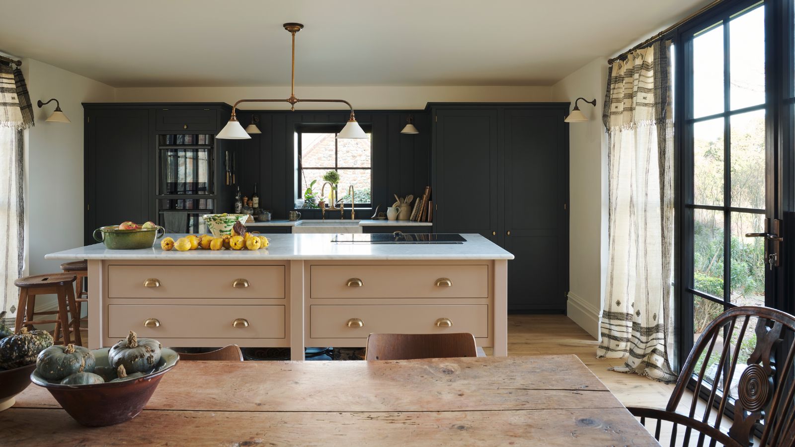 Helle Landhausküche mit dunkelgrünen Schränken und warmrosa Kücheninsel