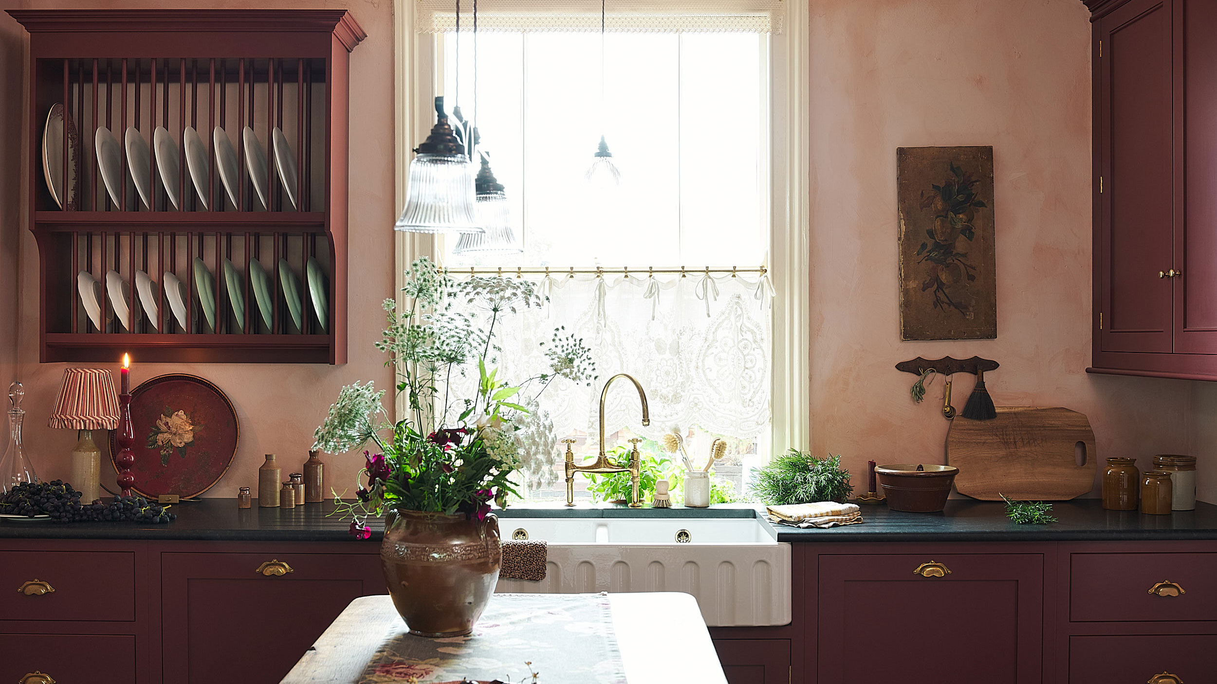 deVOL-Küche im traditionellen englischen Stil mit roten Schränken, rosa Wänden und Holzinsel mit Vase und Blumen 