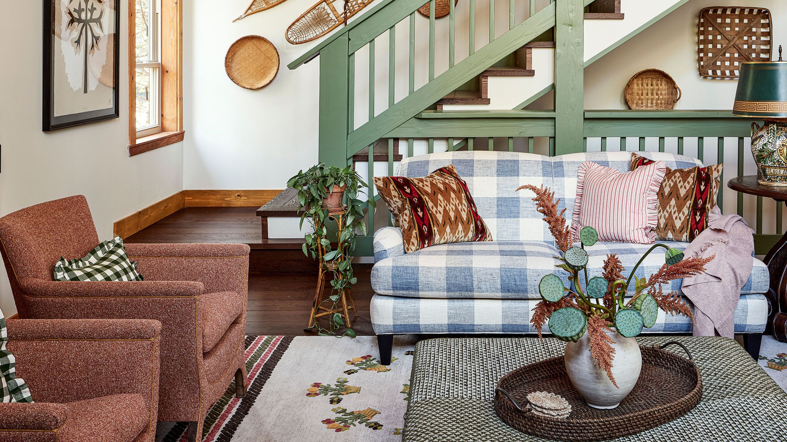 Rustic great room featuring an eclectic mix of wall art, collected objects, and upholstered furniture – the gingham loveseat being the most statement-making of the bunch