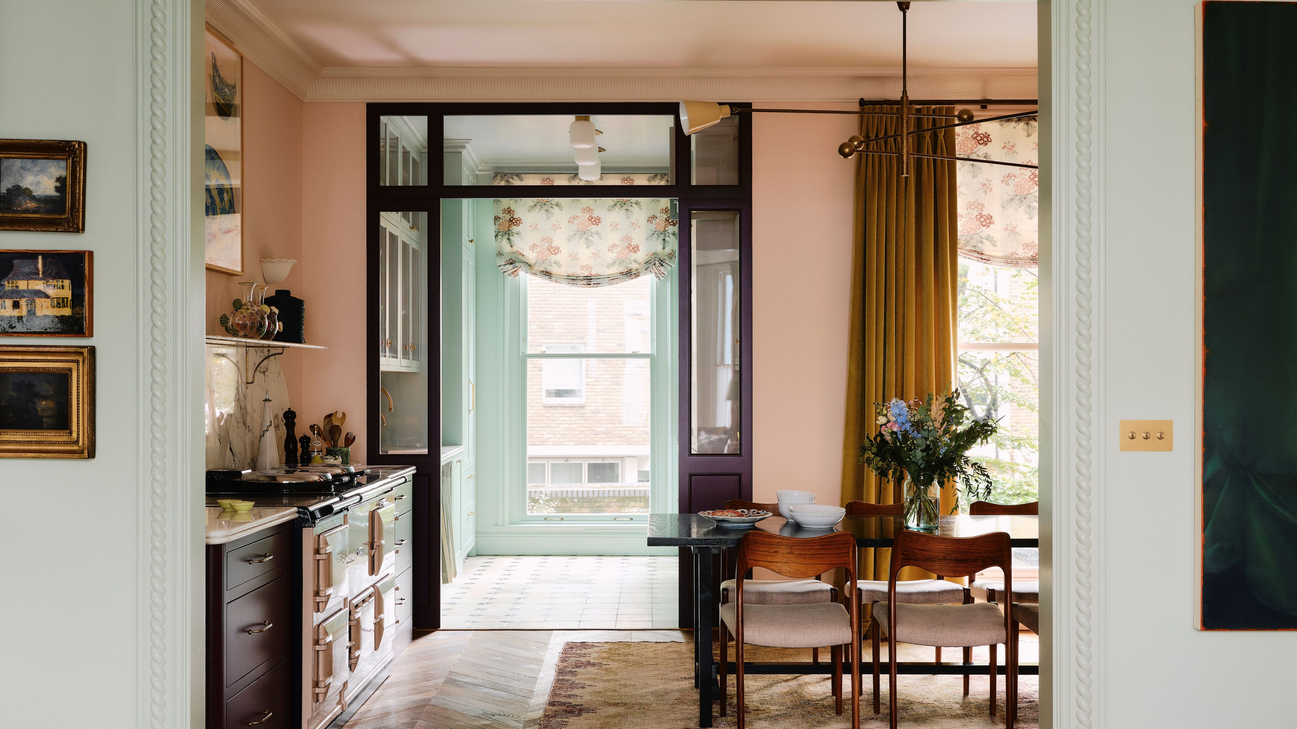 Studio Duggan Küchen-Esszimmer-Kombination mit gesammelten antiken Kunstwerken, einem Holztisch und Stühlen, einem Juteteppich und Messingbeleuchtungskörpern