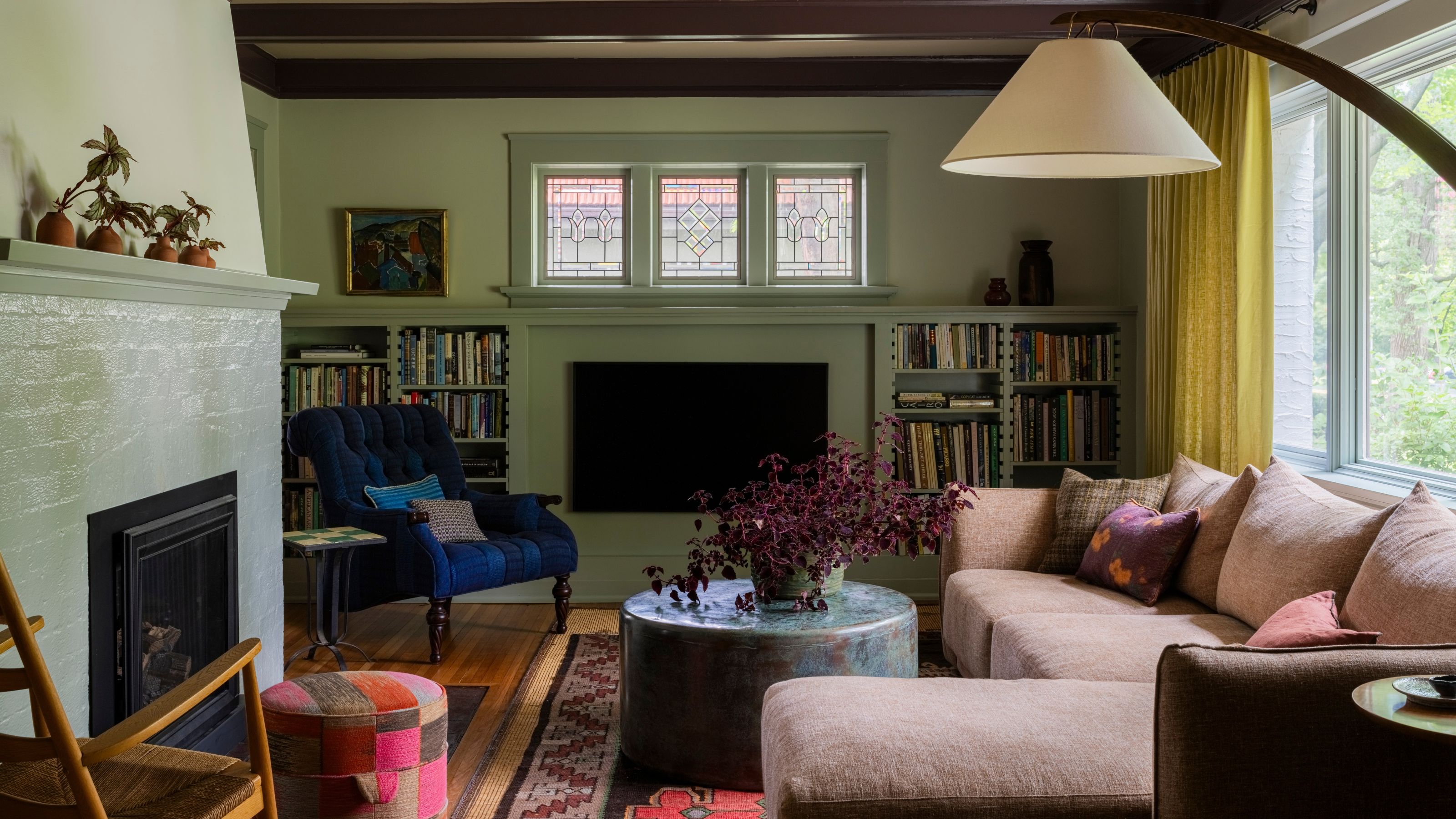 Grünes Wohnzimmer mit rosa Sofa und Deckenbalken