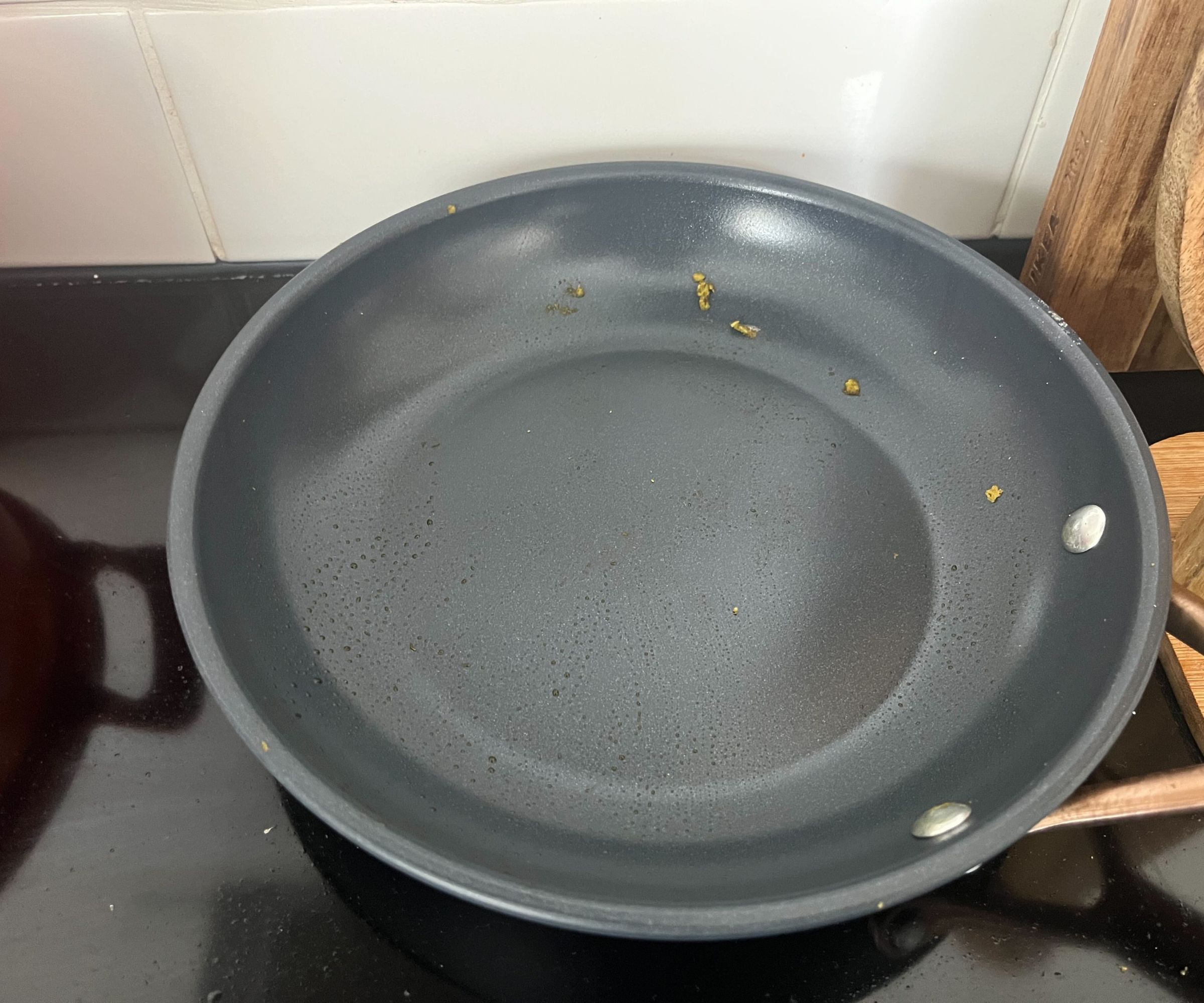 Reste von grünem Pesto in einer kleinen blauen Keramikpfanne.