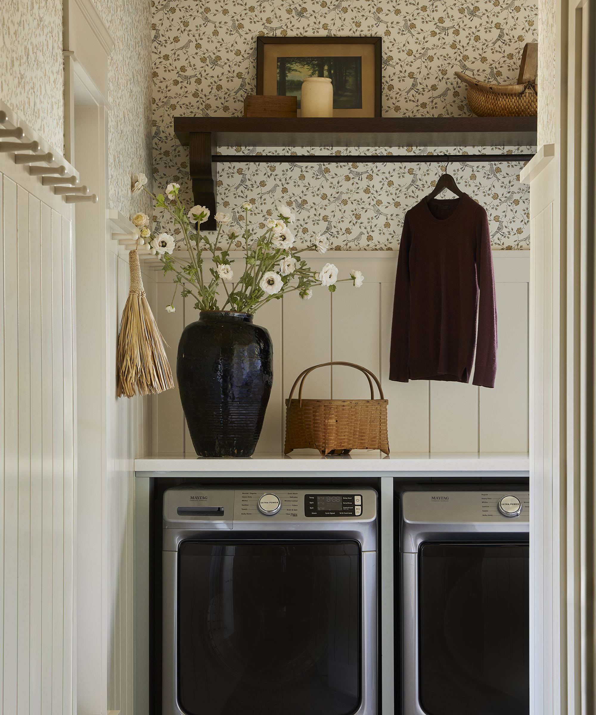 Waschküche mit Blumentapete an der Wand über der Waschmaschine
