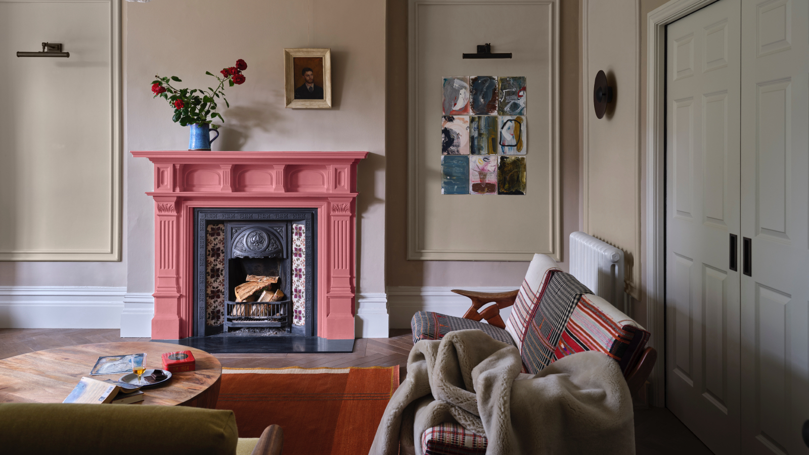 Neutrales Wohnzimmer mit korallenfarbenem Kamin, gestreifter Couch, Kunstwerk, Wandverkleidung, Teppich, Couchtisch, Decken, Farrow & Ball 