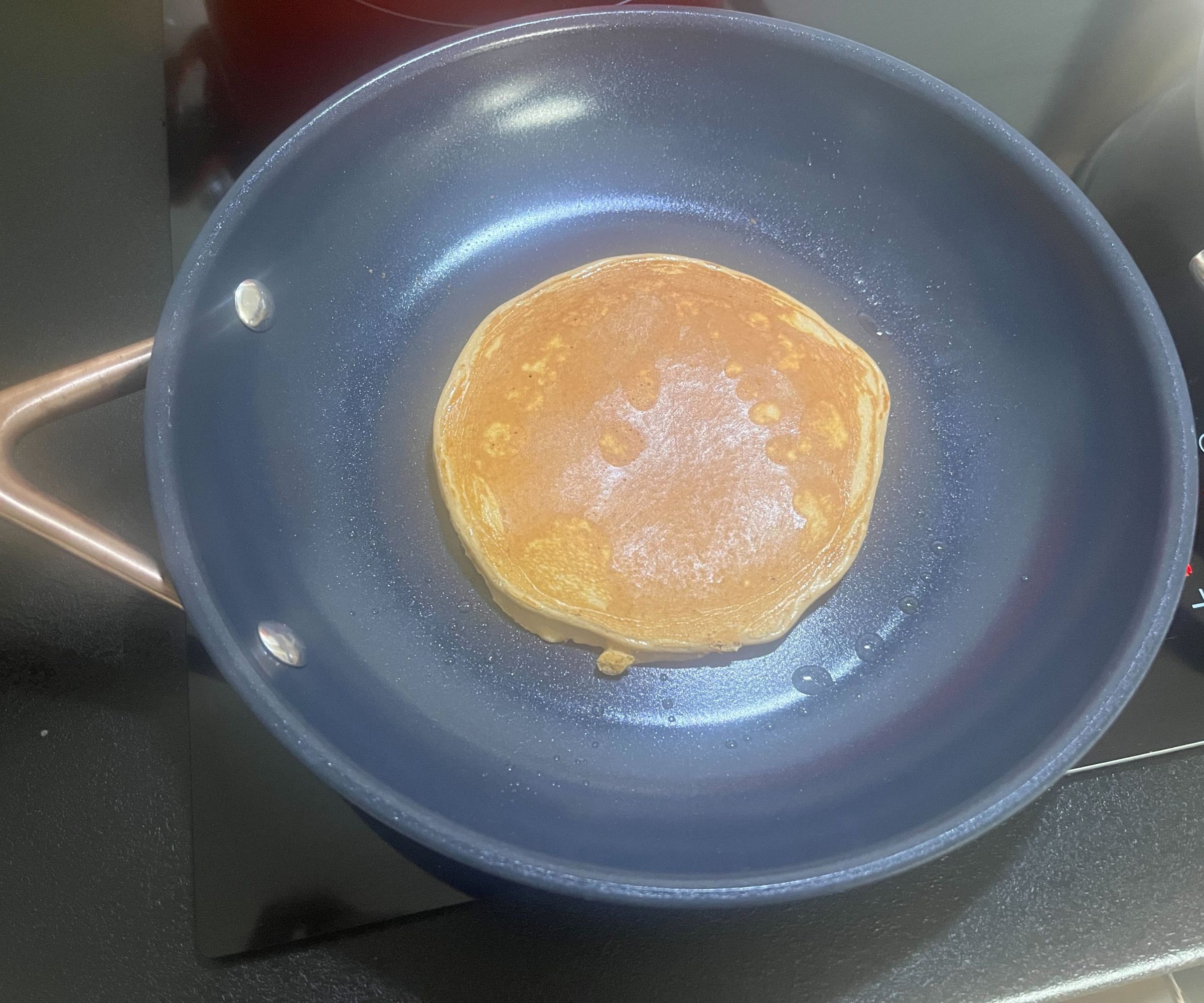 Ein goldener Pfannkuchen in einer kleinen blauen Keramikpfanne