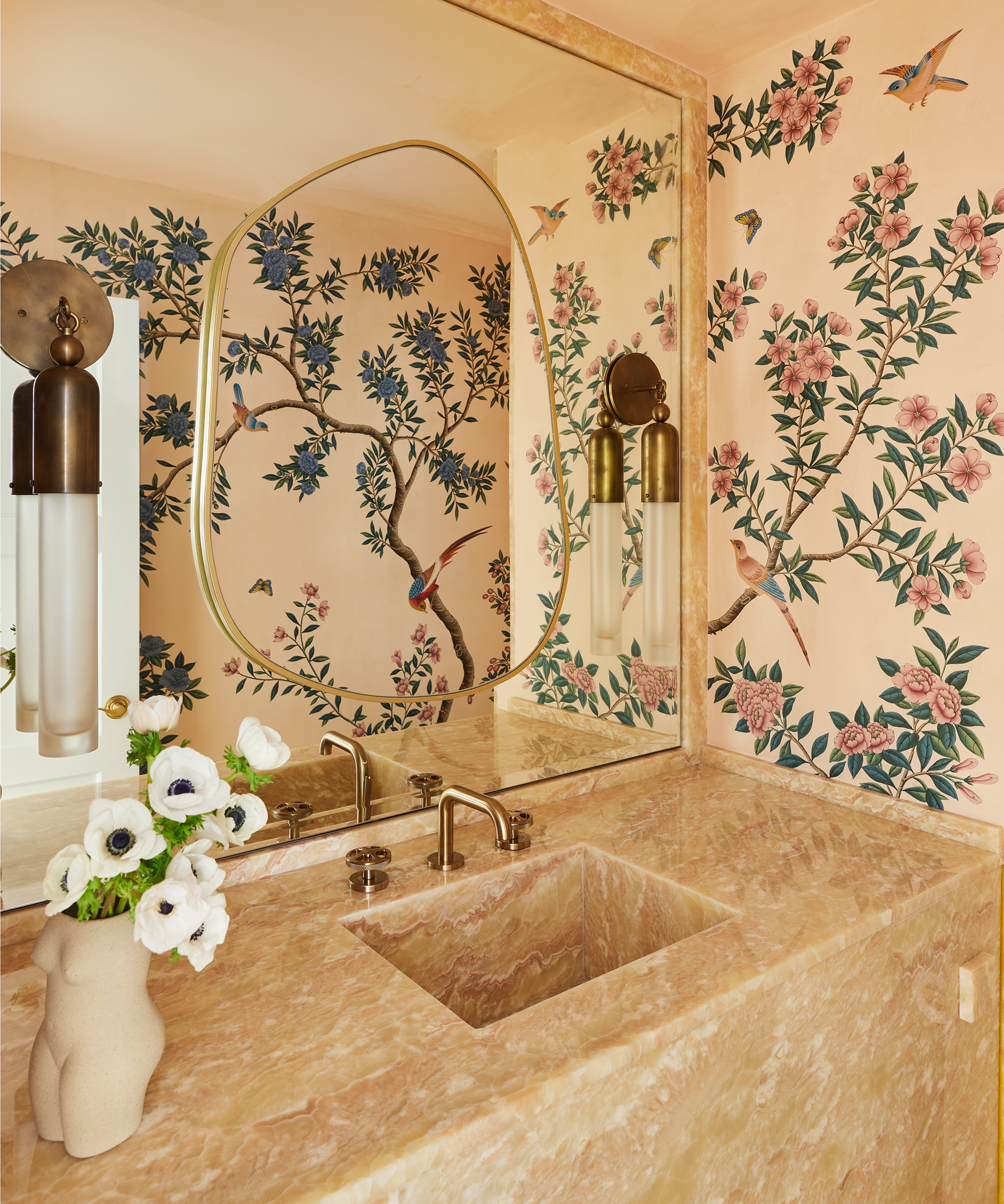 Badezimmer mit Blumentapete und großem Spiegel über einem Steinwaschbecken
