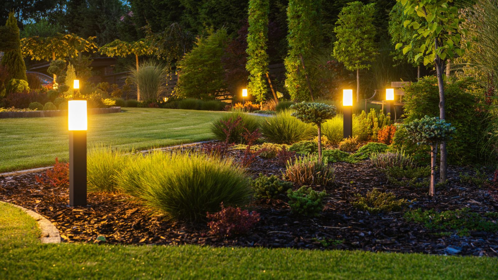 LED-Lichtmasten in einem Garten in der Dämmerung