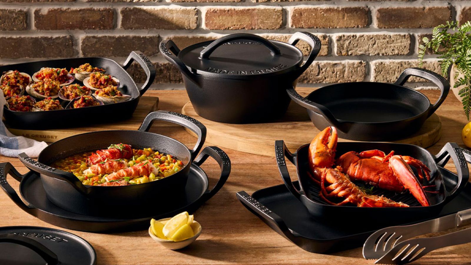 Le Creuset Alpine Collection auf einem Holztisch im Freien. 