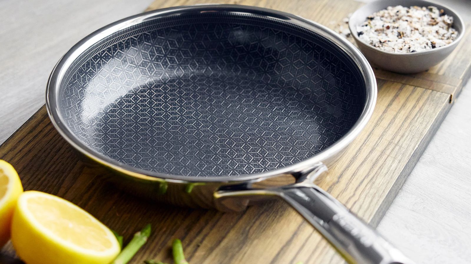 GreenPan Spectra Thermobond Bratpfanne auf einem Holzschneidebrett, daneben einige halbierte Zitronen. 