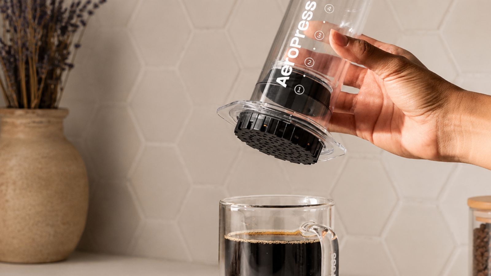 Eine klare AeroPress über einer klaren Tasse Kaffee